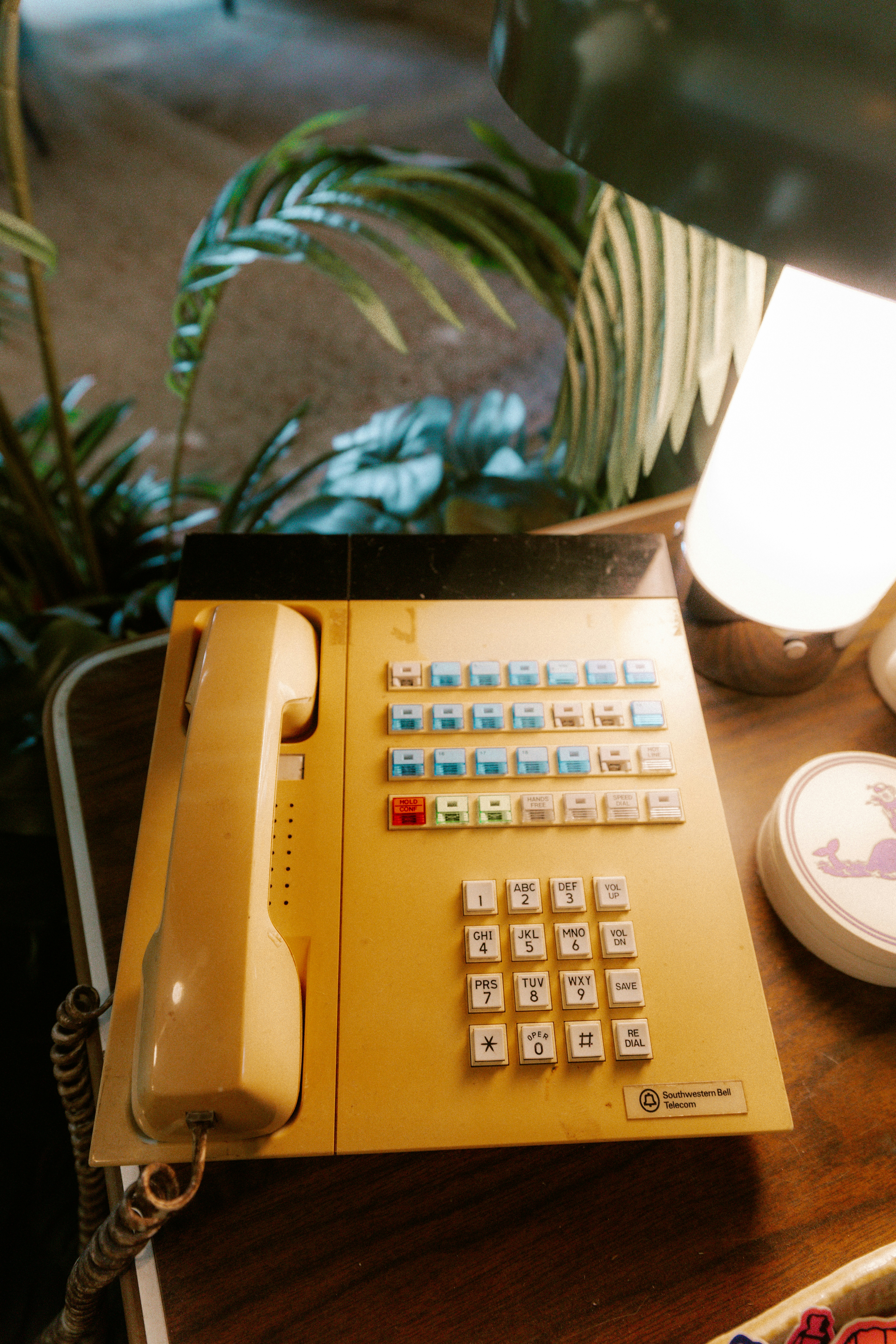 Retro yellow desk phone with keypad and buttons.