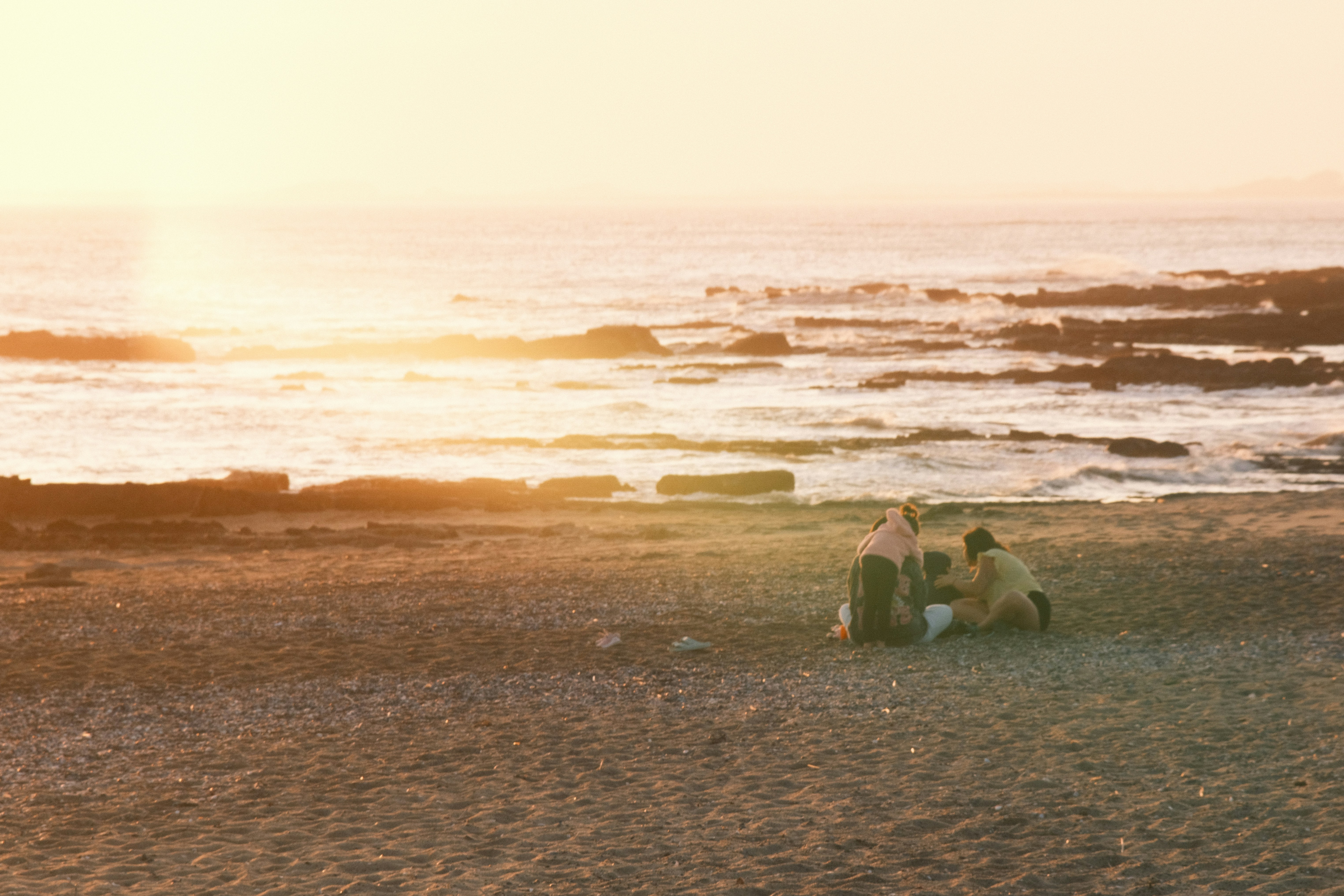 Couple enjoying a sunset picnic on the beach.