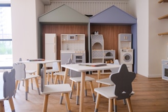 Children's play kitchen area with small tables and chairs