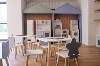 Children's play kitchen area with small tables and chairs