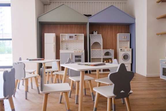 Children's play kitchen area with small tables and chairs