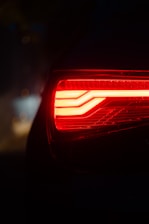 Close-up of a car's red taillight at night.