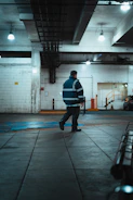Man in reflective jacket walks in industrial building