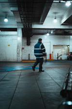 Man in reflective jacket walks in industrial building