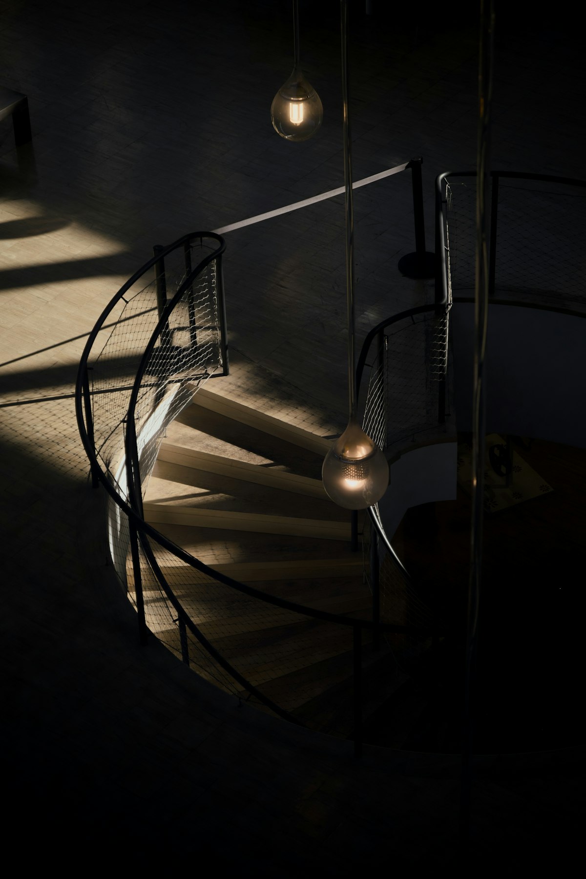 A spiral staircase in warm ambient light — the studio's design philosophy
