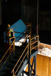 Worker feeding blue material onto conveyor belt