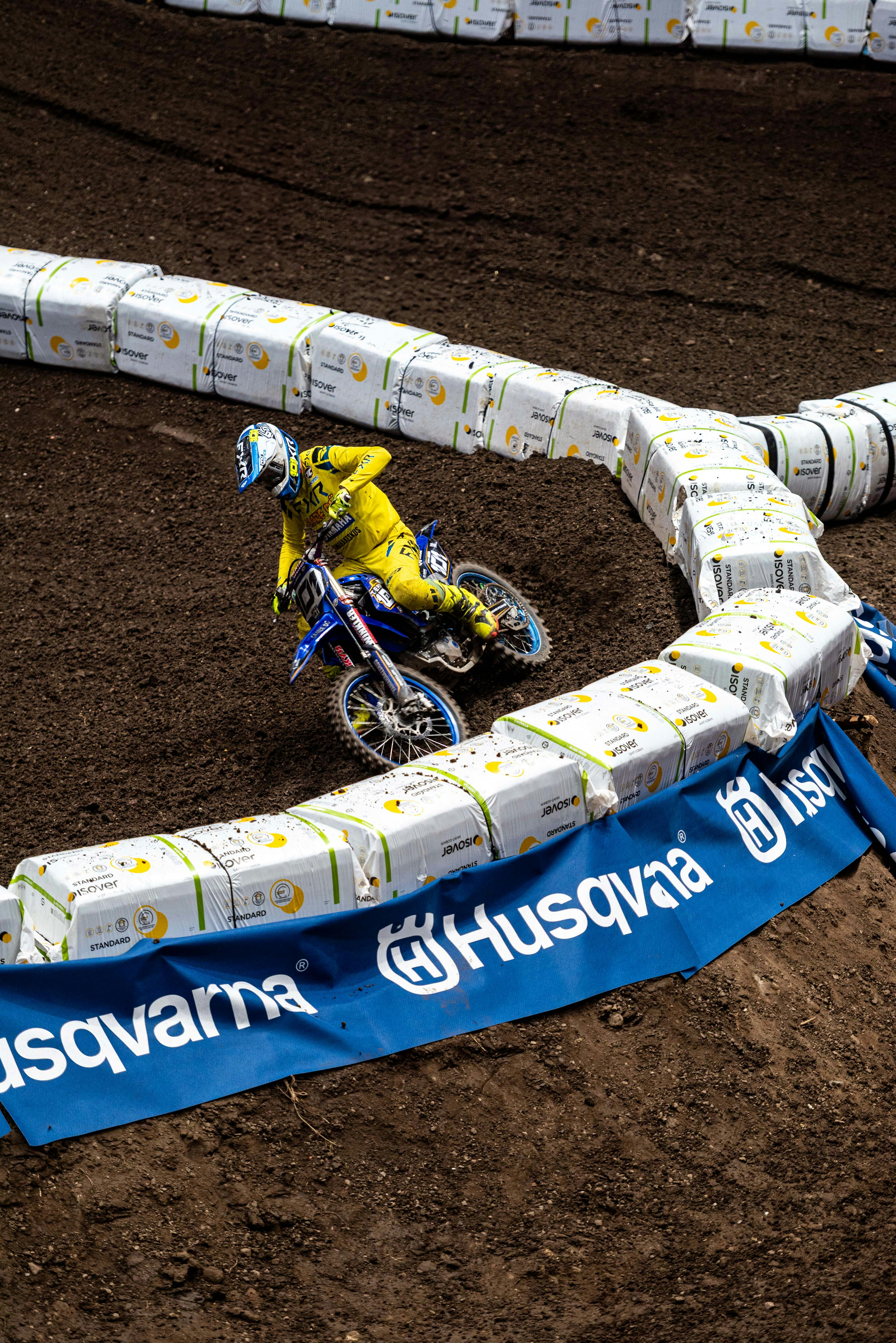 Motocross rider in yellow suit on dirt track