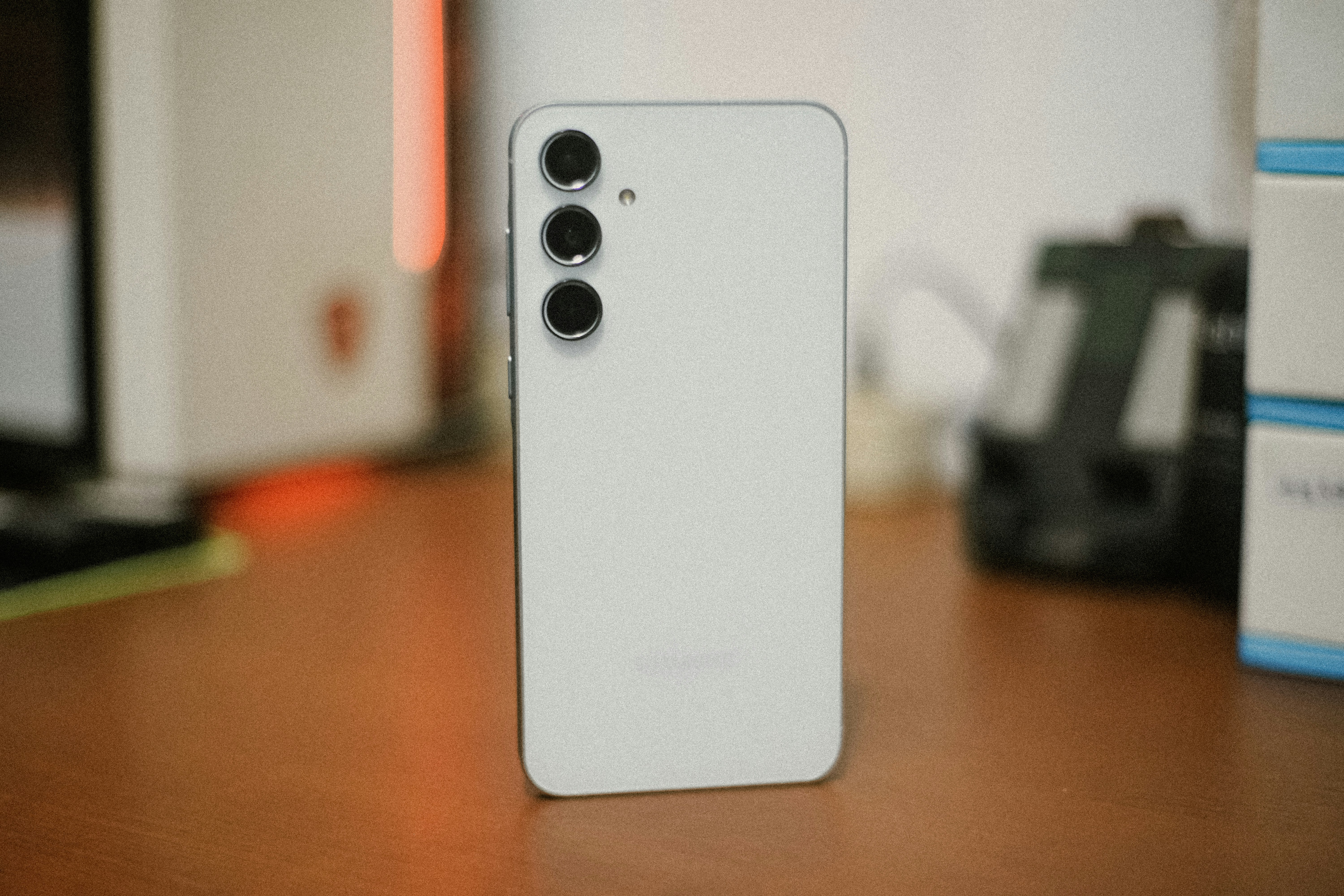 White smartphone with three rear cameras on desk