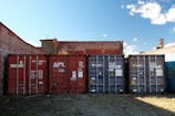 Shipping containers lined up against brick buildings