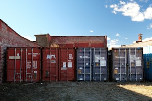 Shipping containers lined up against brick buildings