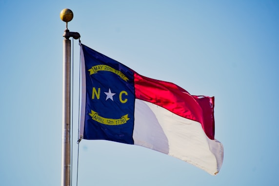 North carolina flag waving against a blue sky