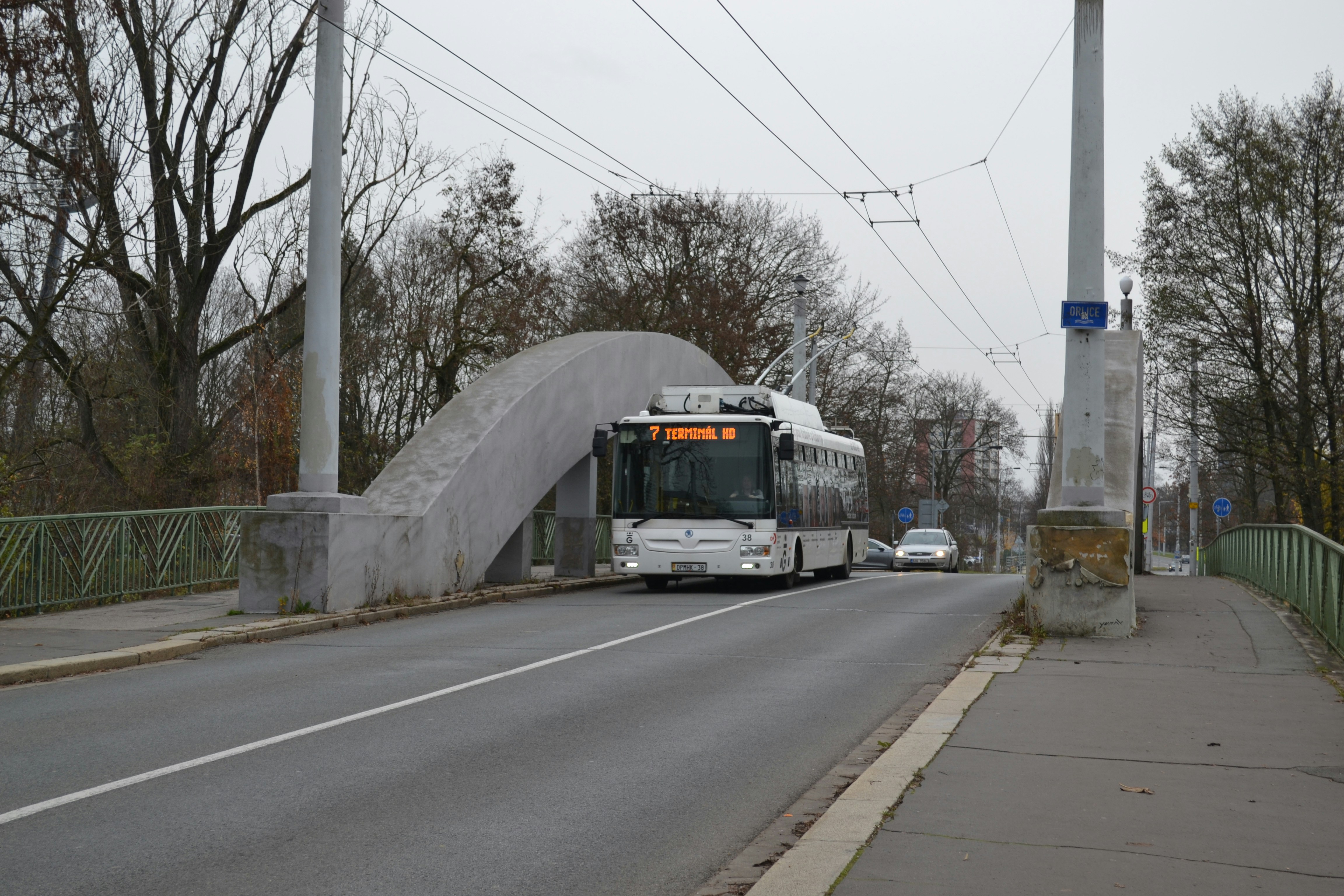 Trolleybus driving on a bridge over a road.