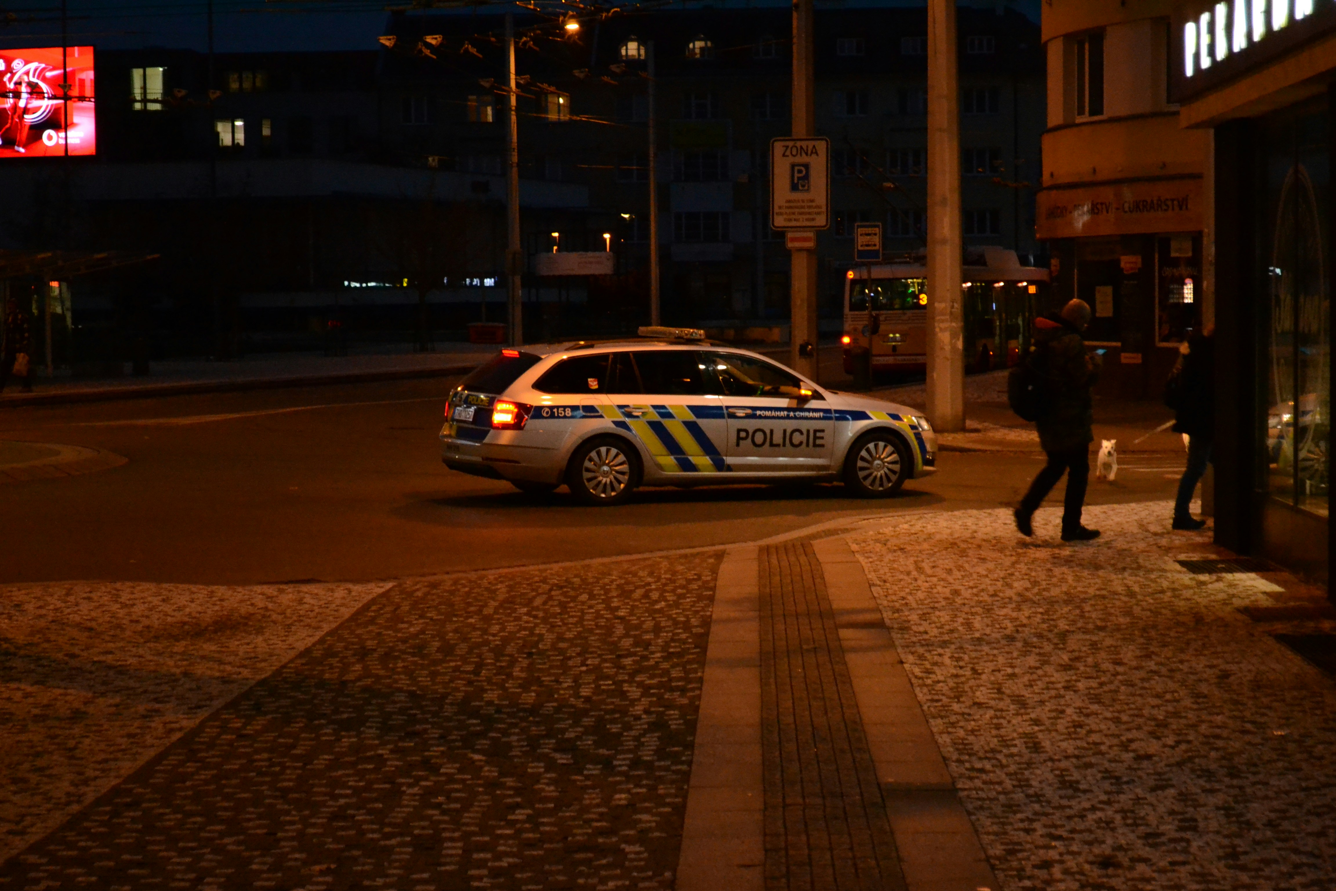 Police car parked on a city street at night.
