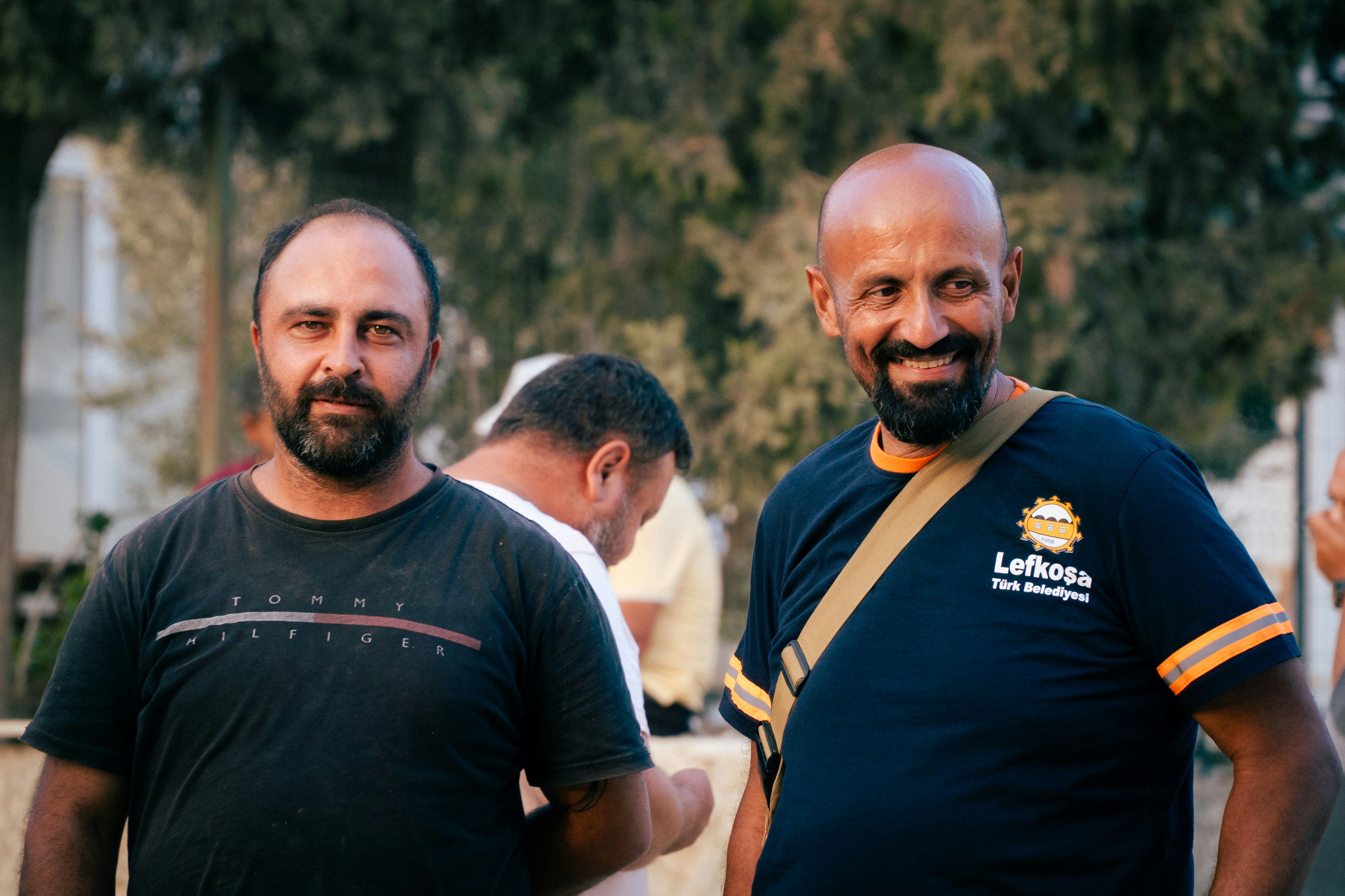 Two men with beards smiling outdoors smiling outdoors
