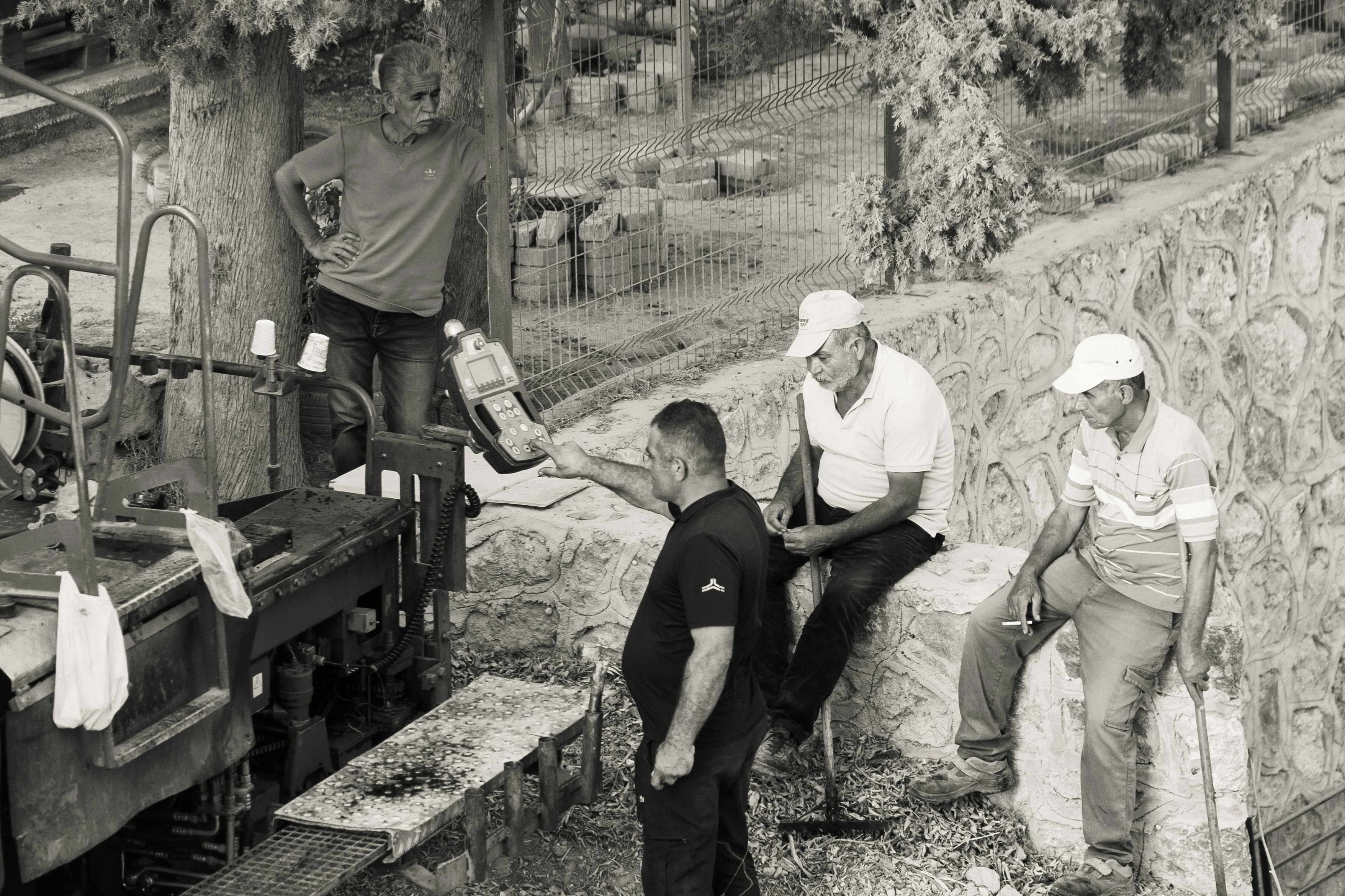 Men working with hay bales and machinery