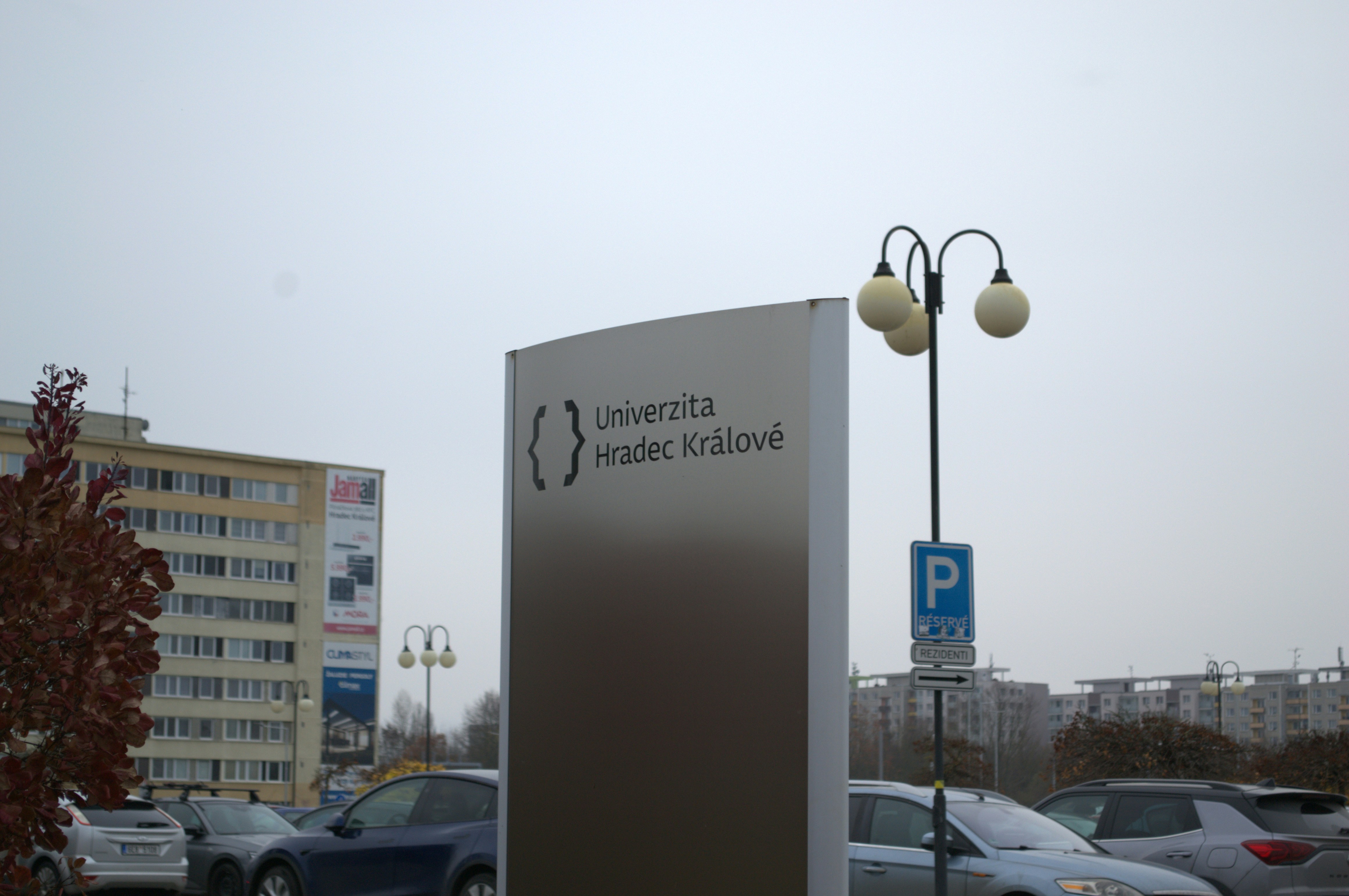 University sign with cars and buildings