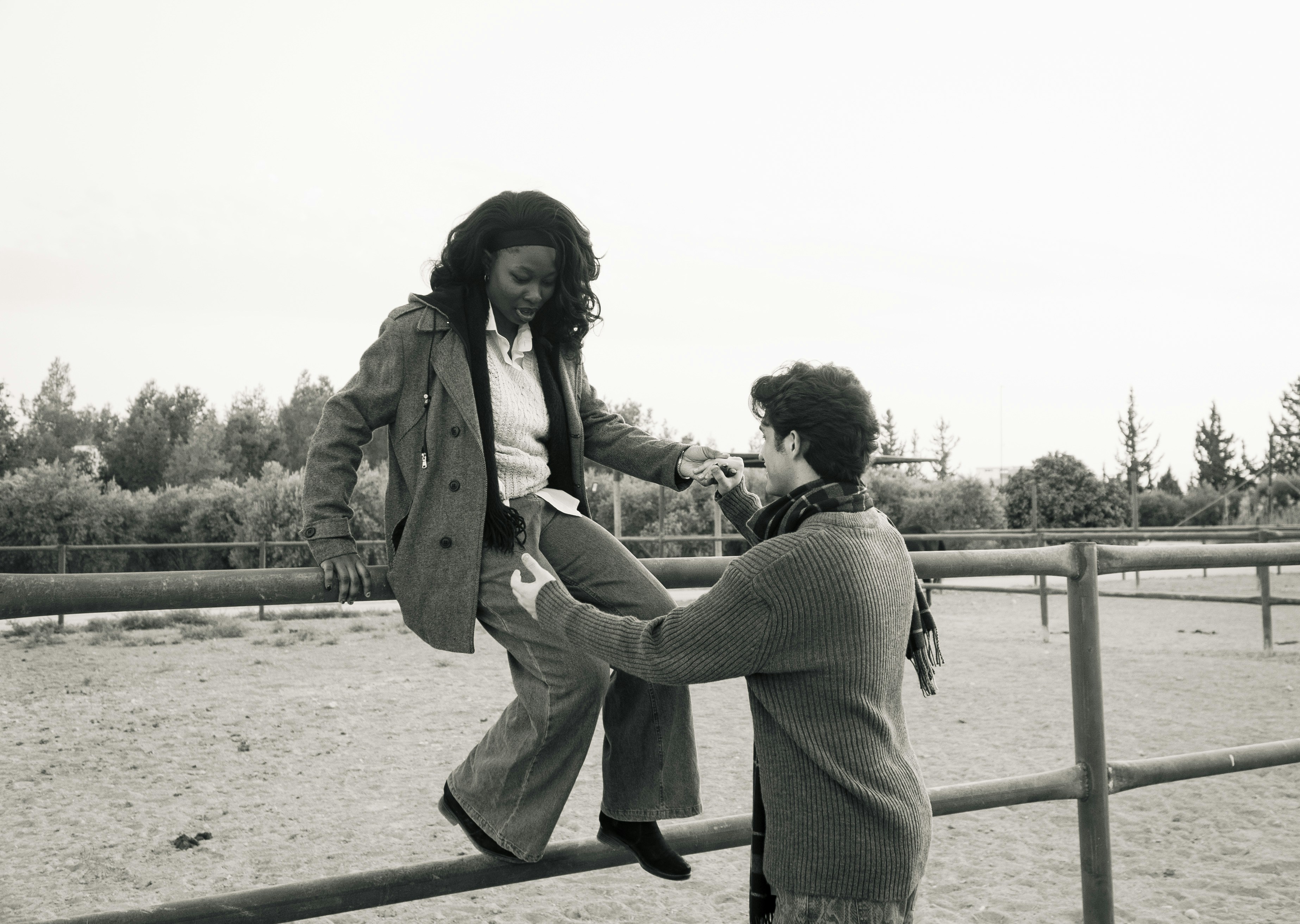 Two people interacting on a fence