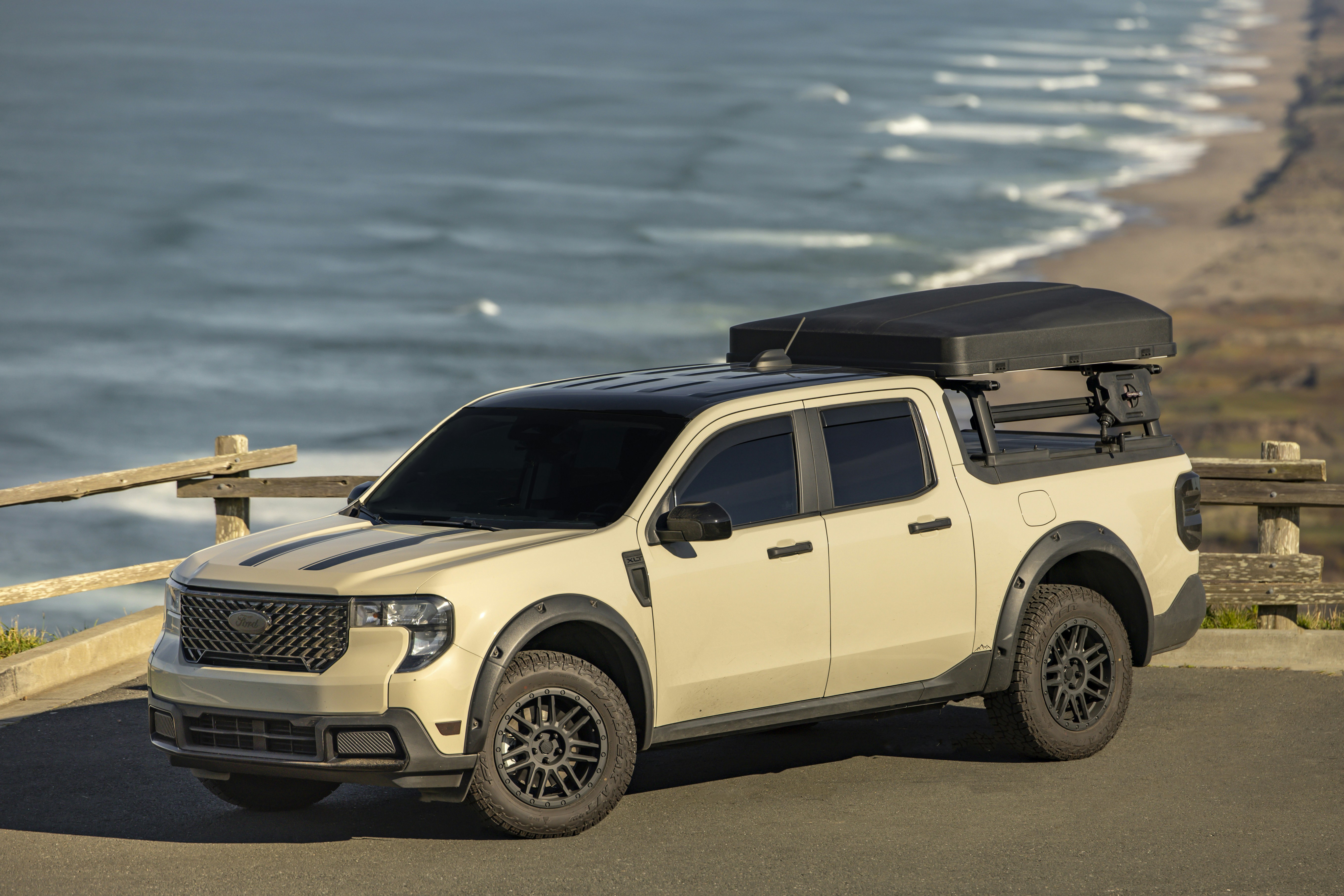 Tan pickup truck with rooftop tent by the ocean