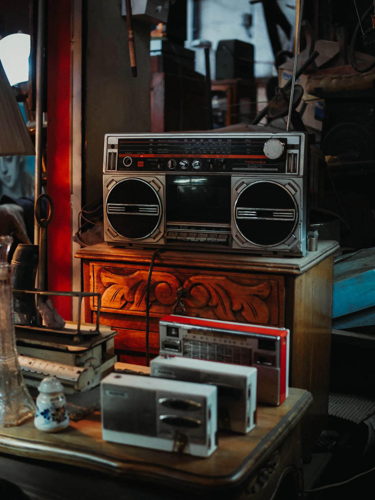 Vintage boombox and radios arranged on antique furniture