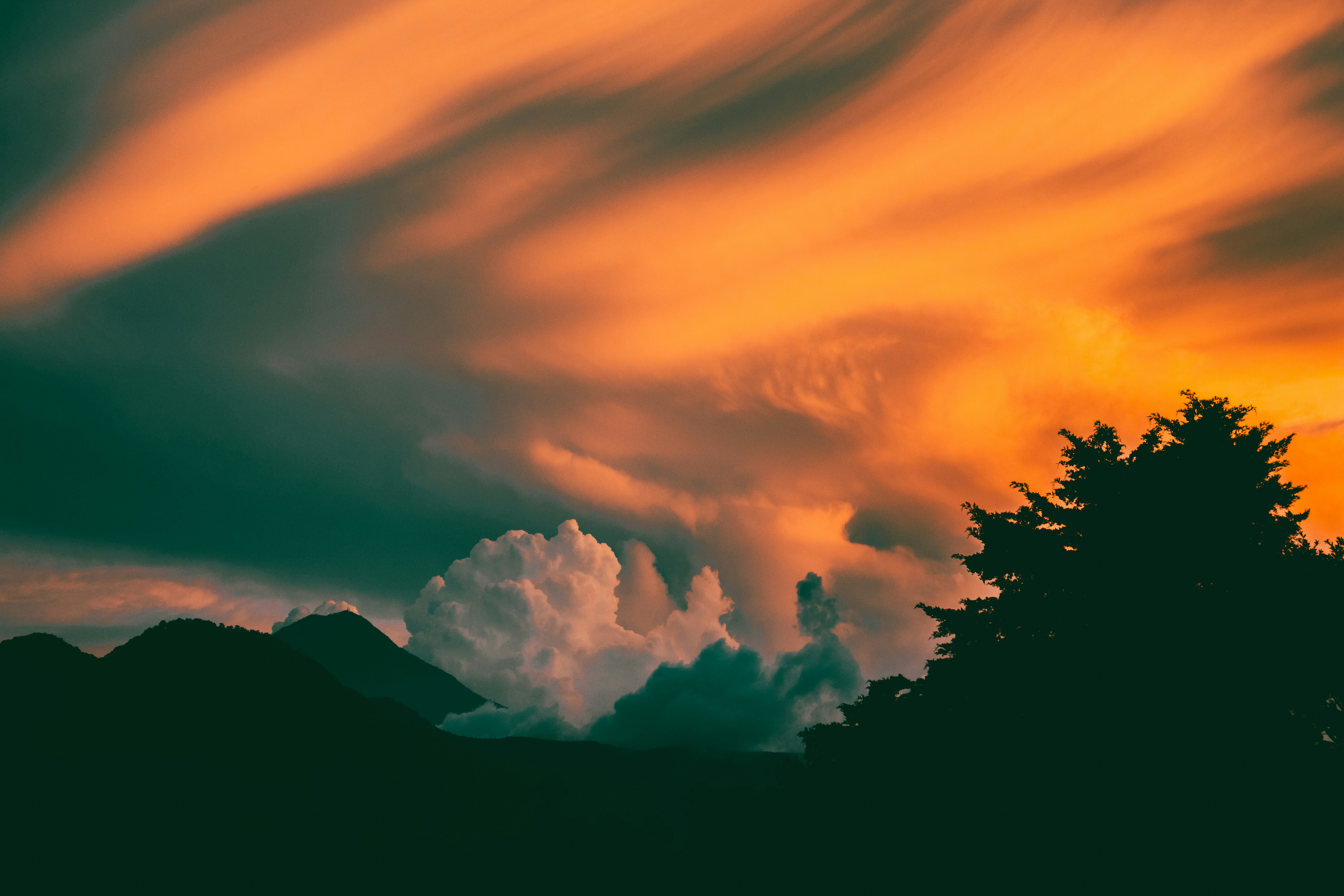 Dramatic sunset clouds over silhouetted landscape