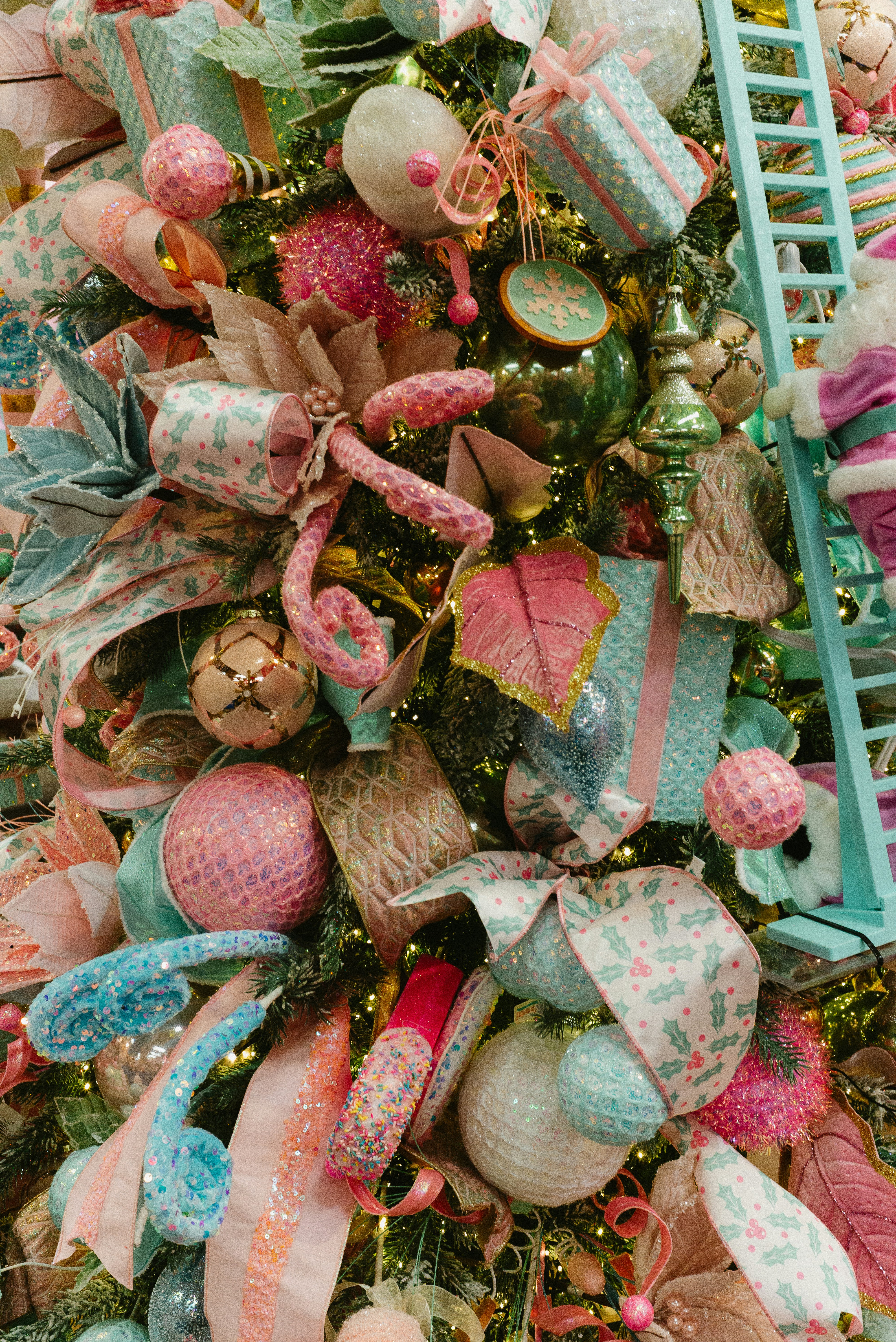 Un albero di Natale decorato con ornamenti rosa e blu.