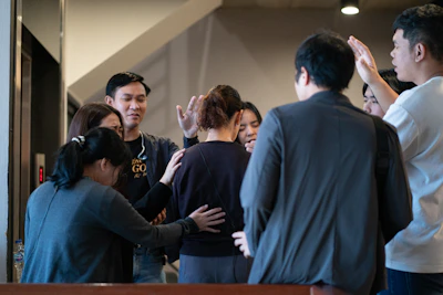 Group of people praying around a woman