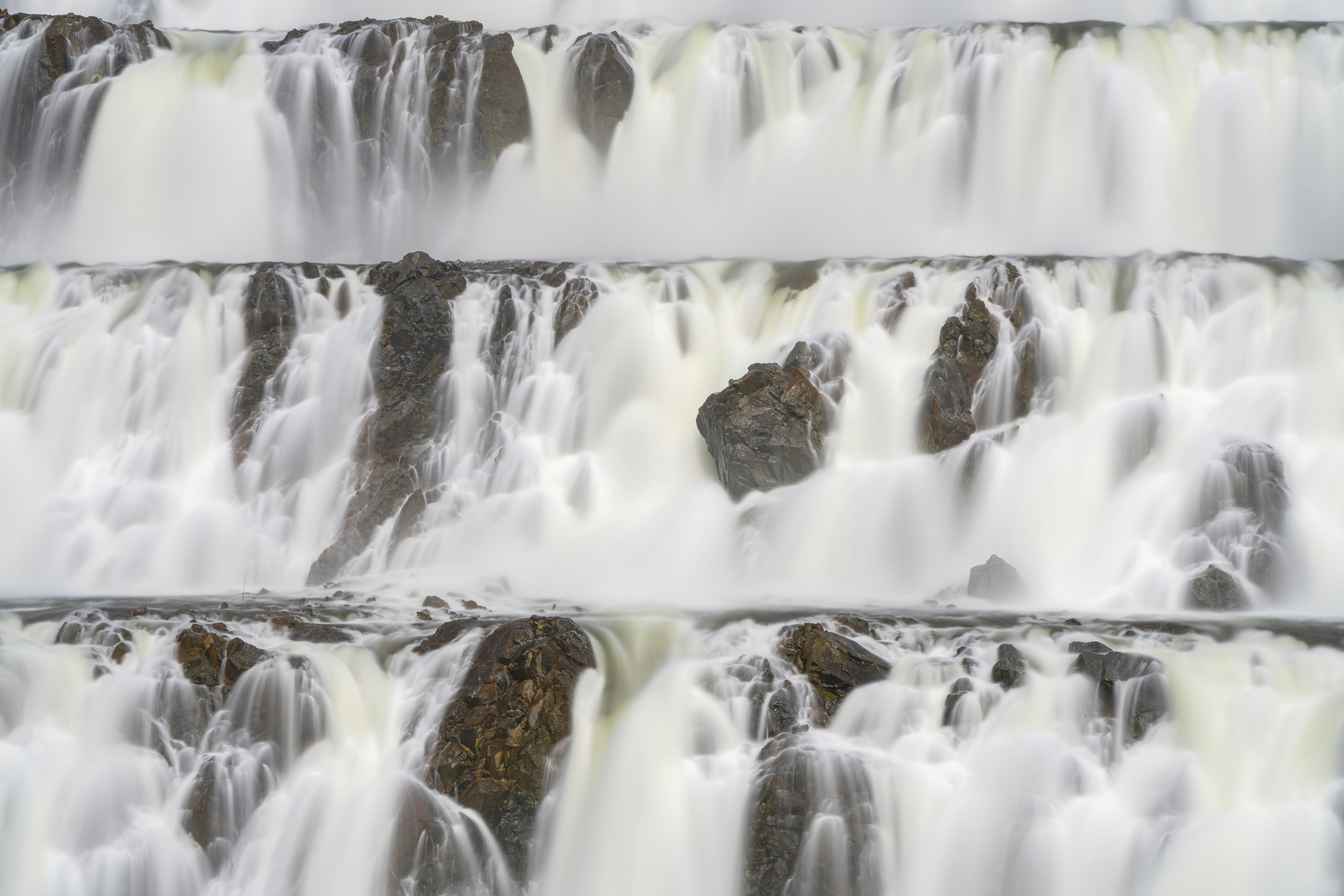 Cascading water flows over tiered rocks.