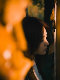 Young woman looking out a window at night
