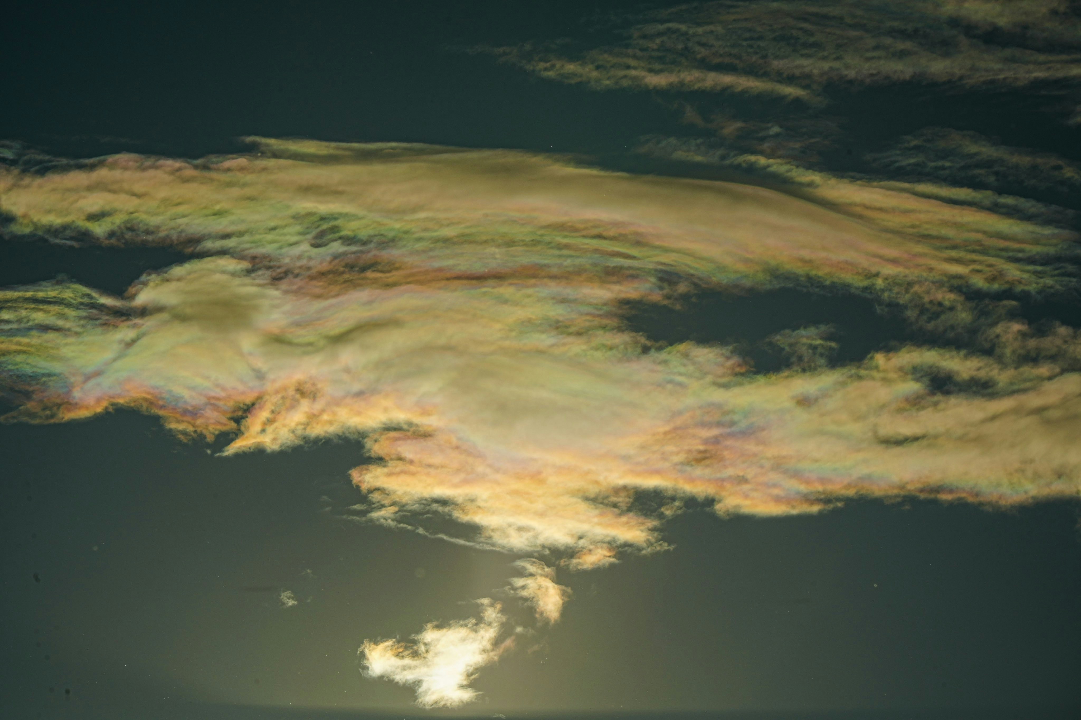 Iridescent clouds glowing in the dark sky at sunset