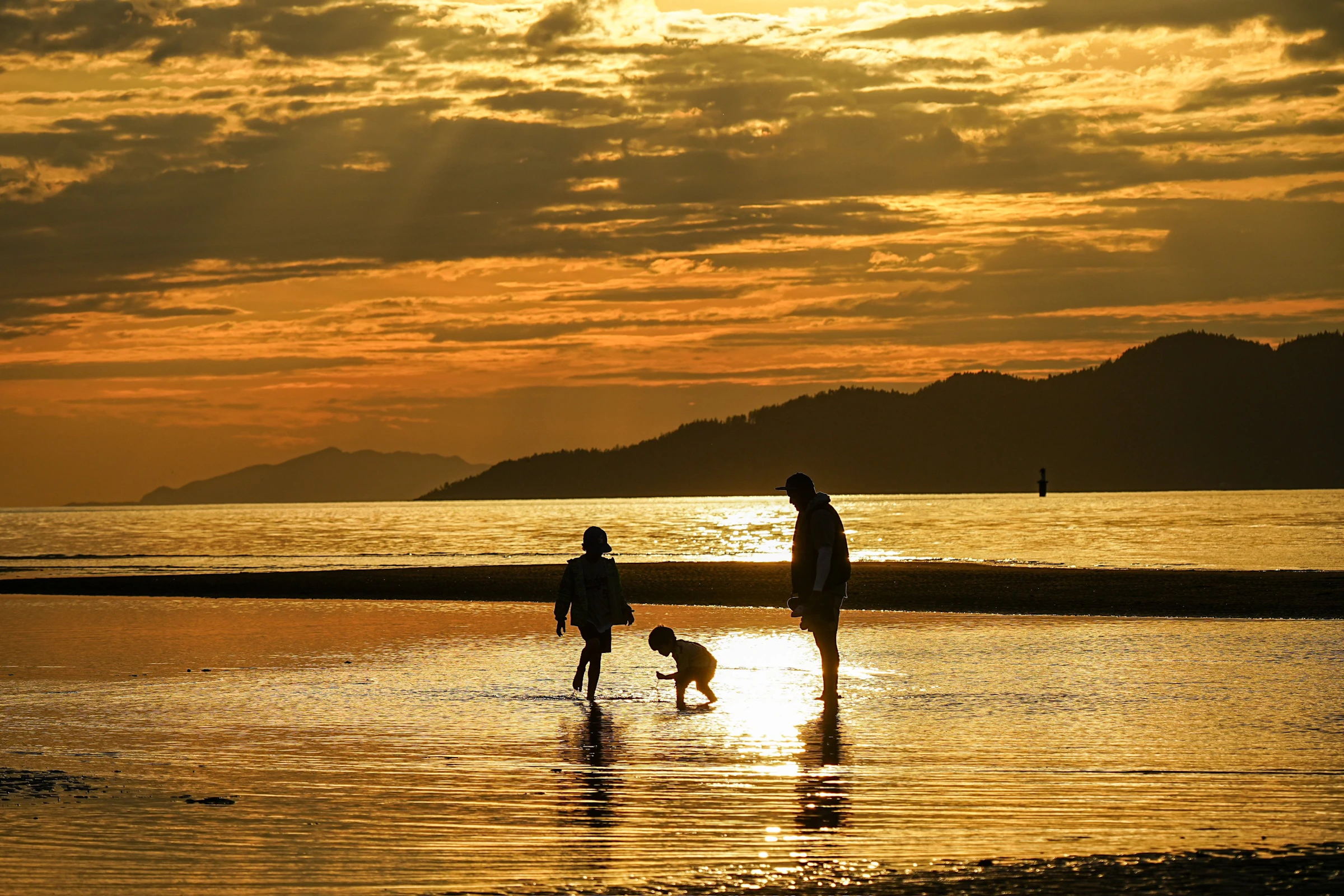 A family walking together on the beach at sunset