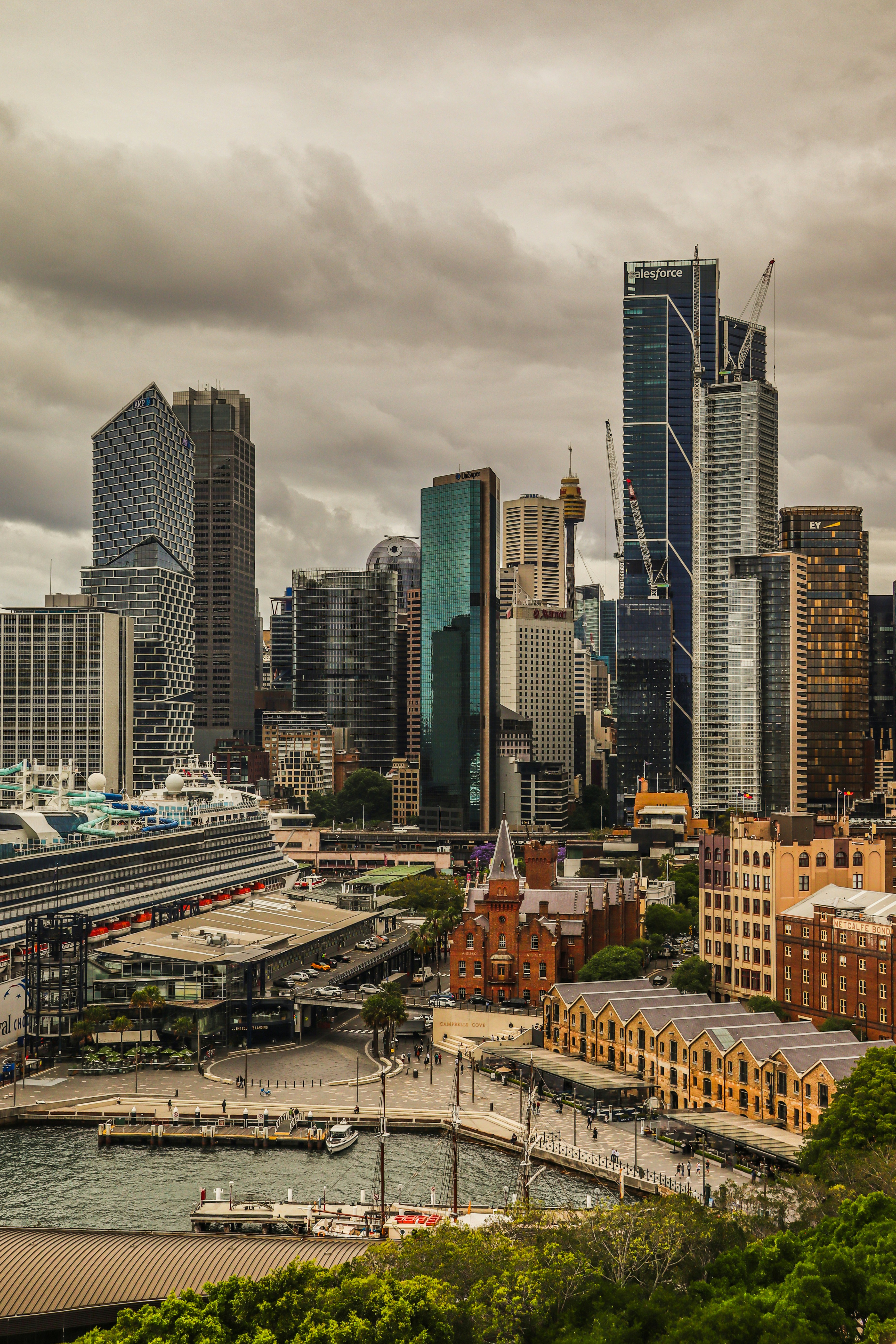 Modern cityscape with skyscrapers and a cruise ship.