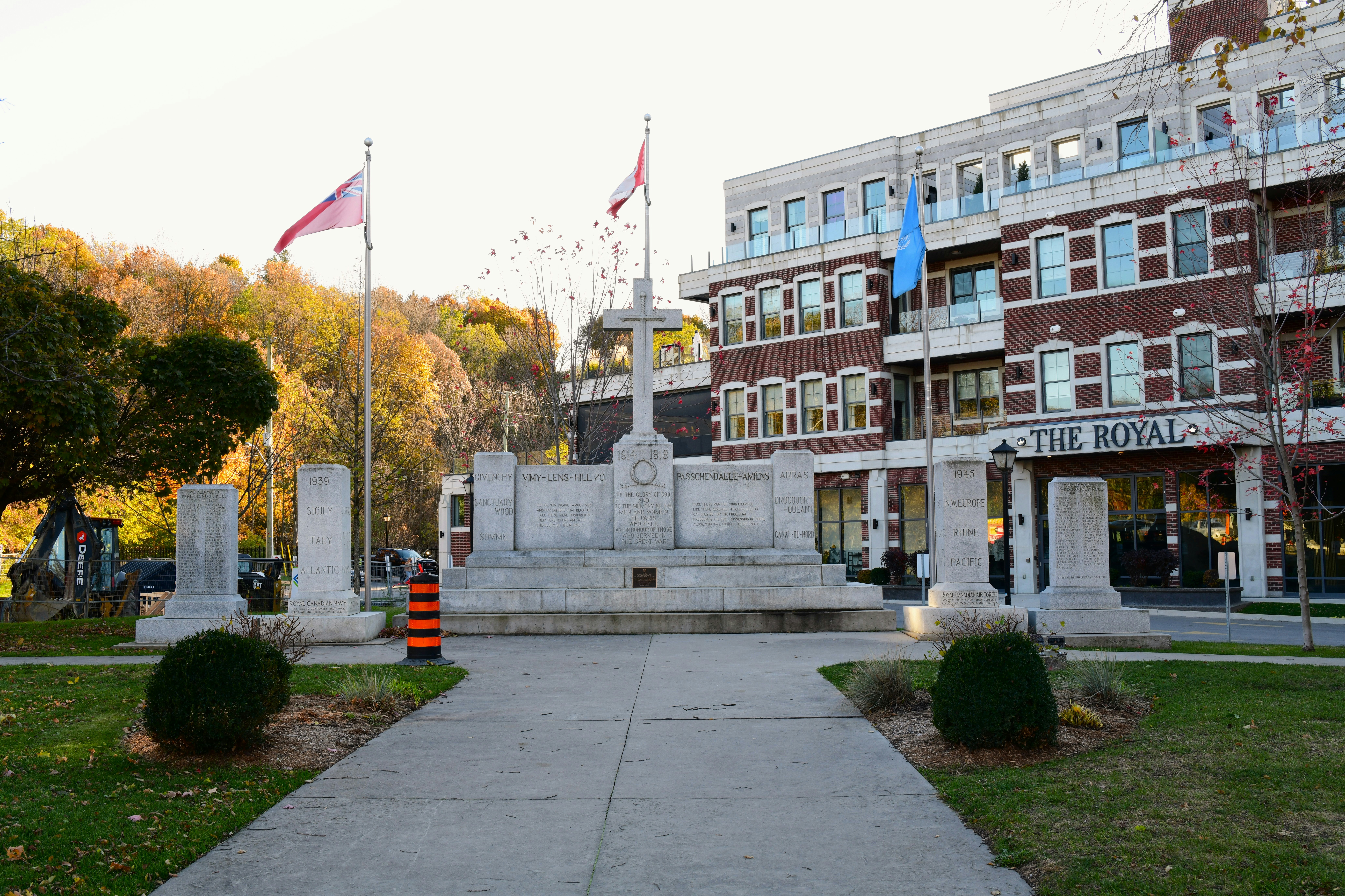 War memorial with flags and building in background