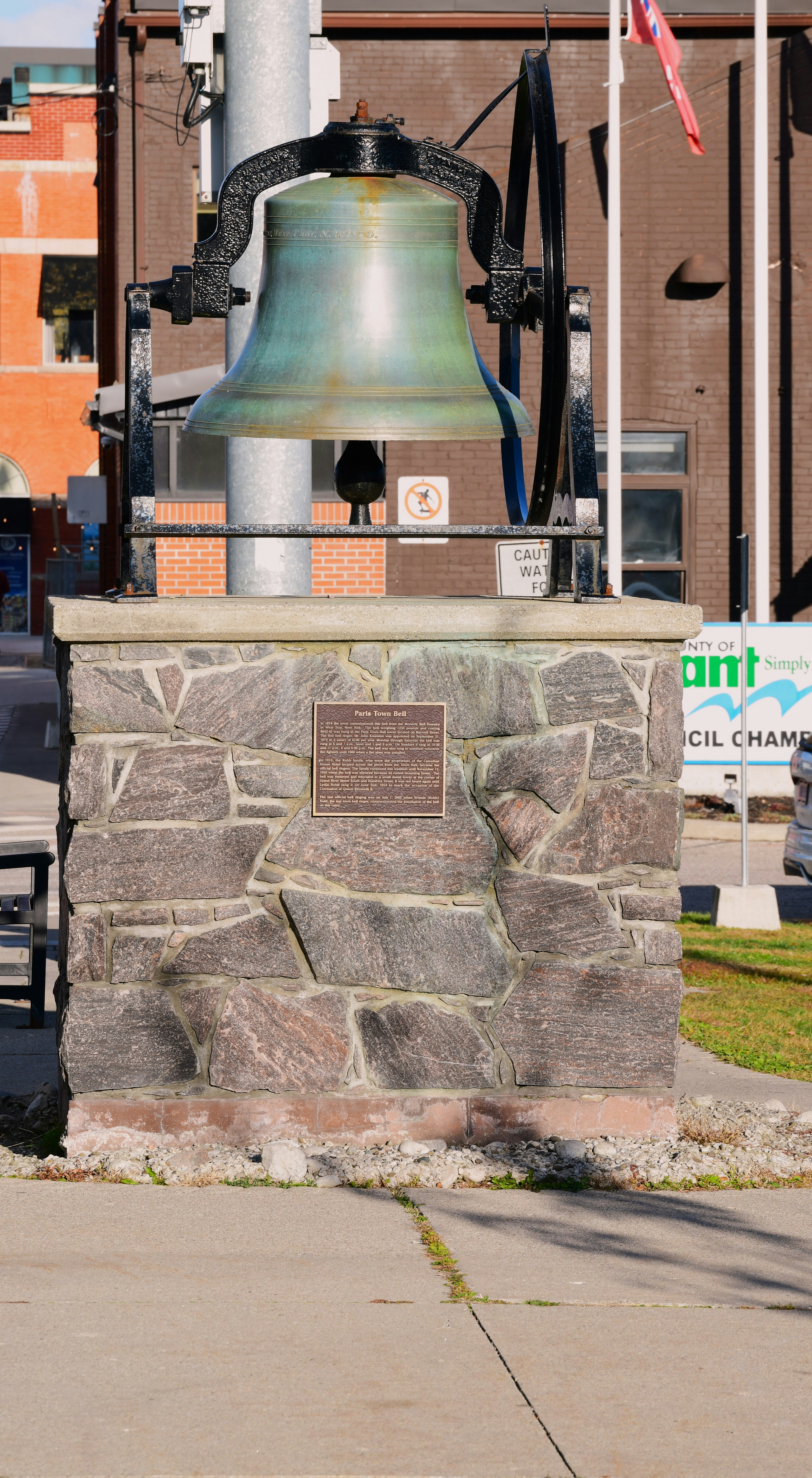 A large bell mounted on a stone pedestal.