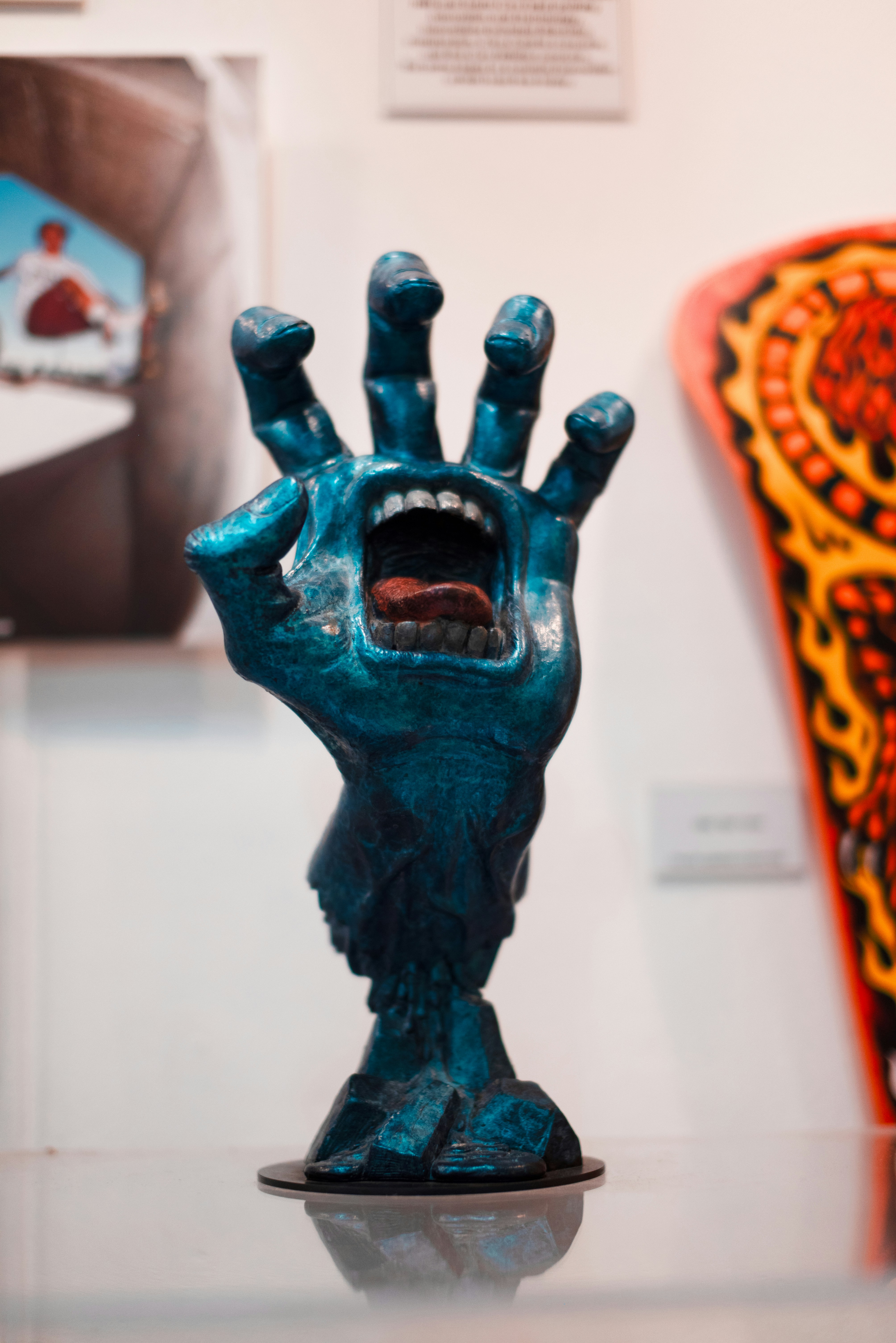 A blue hand sculpture with an open mouth
