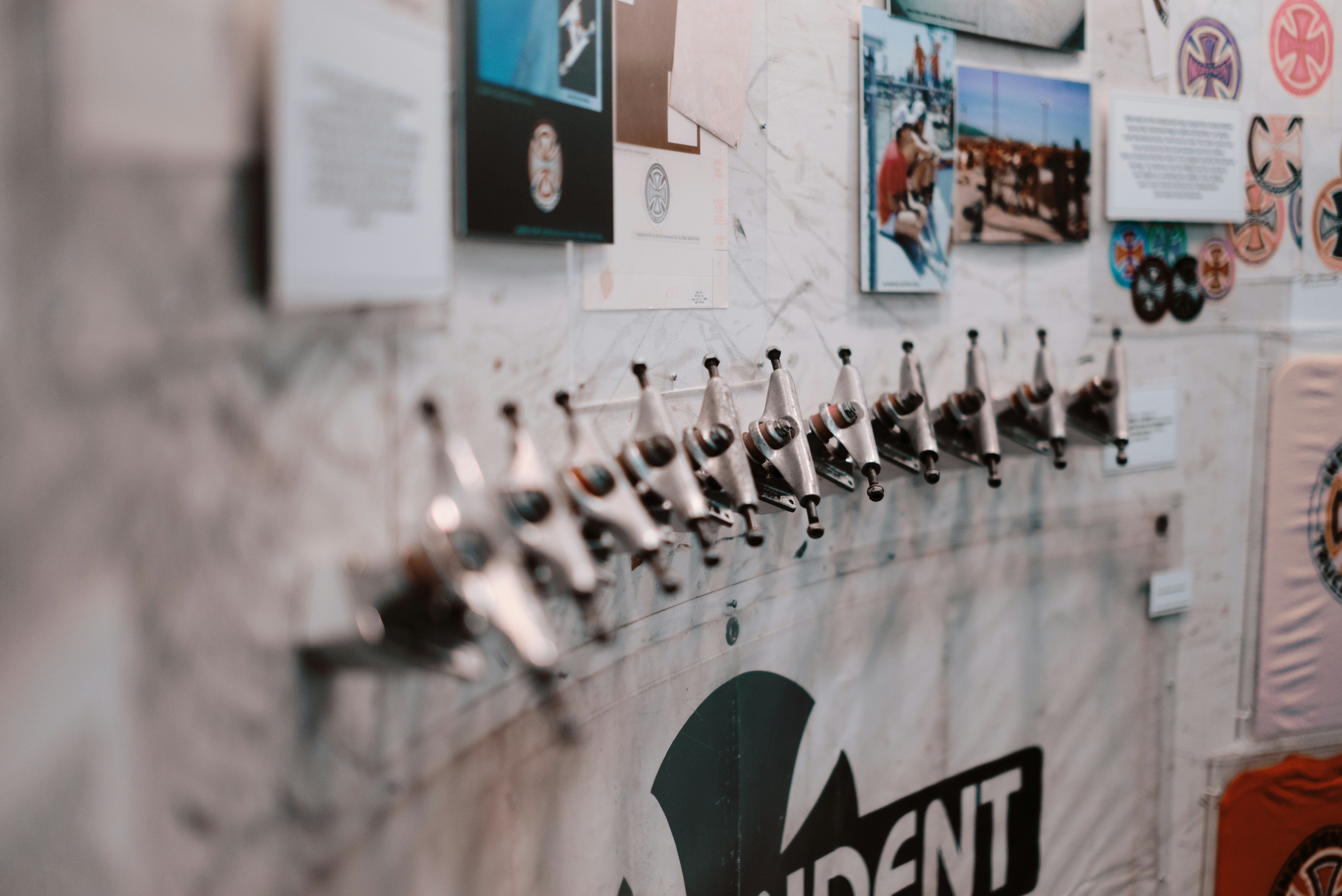 Row of skateboard trucks mounted on a wall.