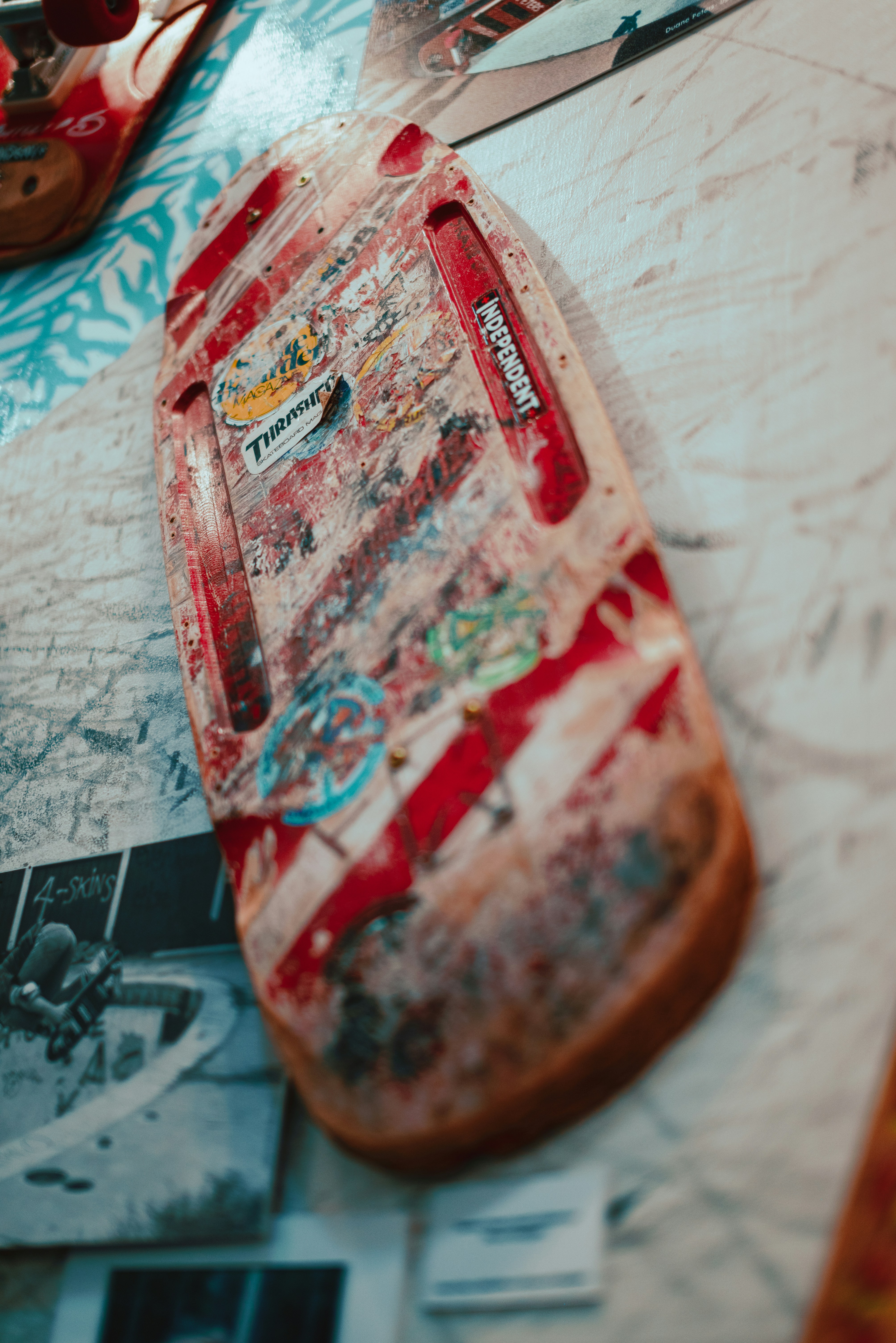 Old skateboard deck with stickers and red stripes