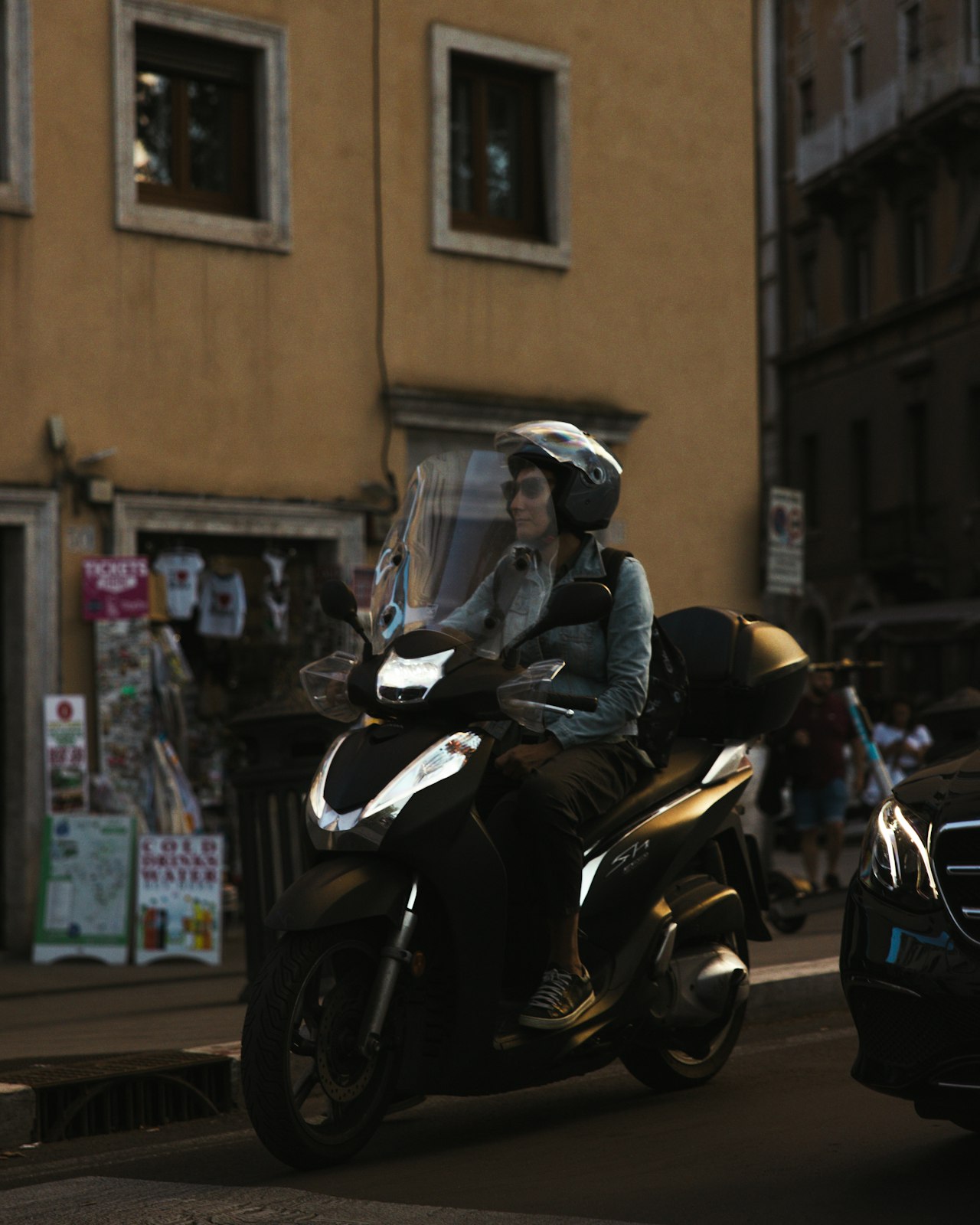 Scooter 125 en circulation dans une rue urbaine animée
