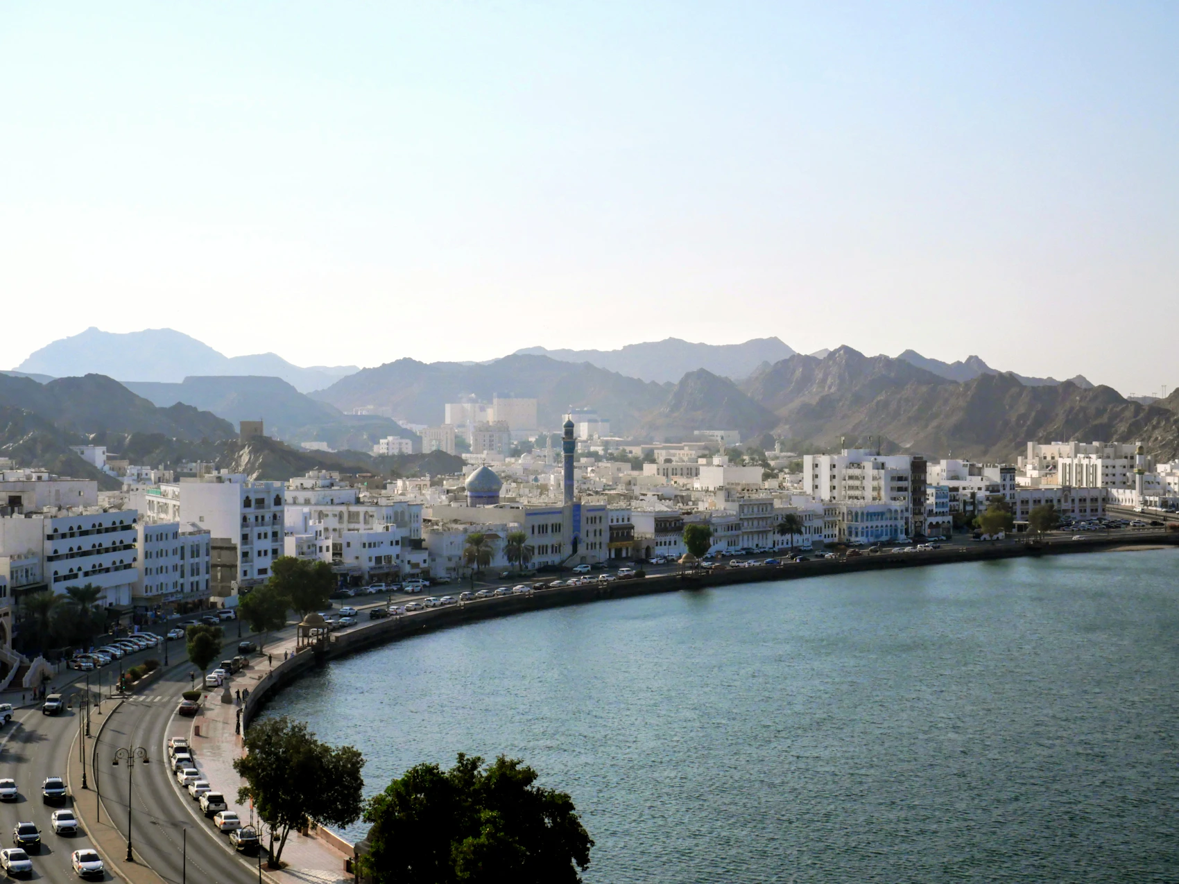 Mutrah Corniche curving around the water beneath the mountains of Muscat