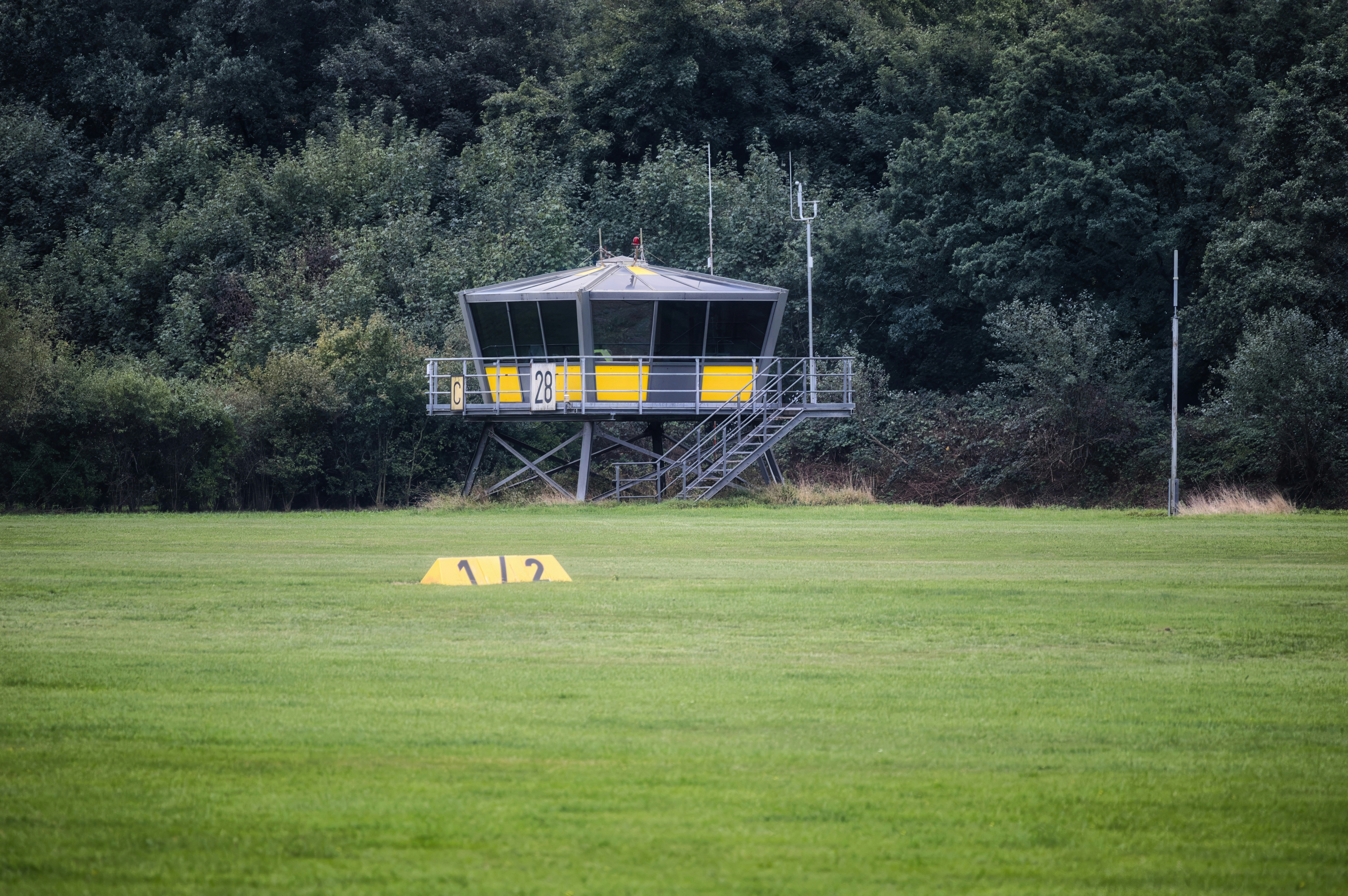 Control tower in a grassy field with trees