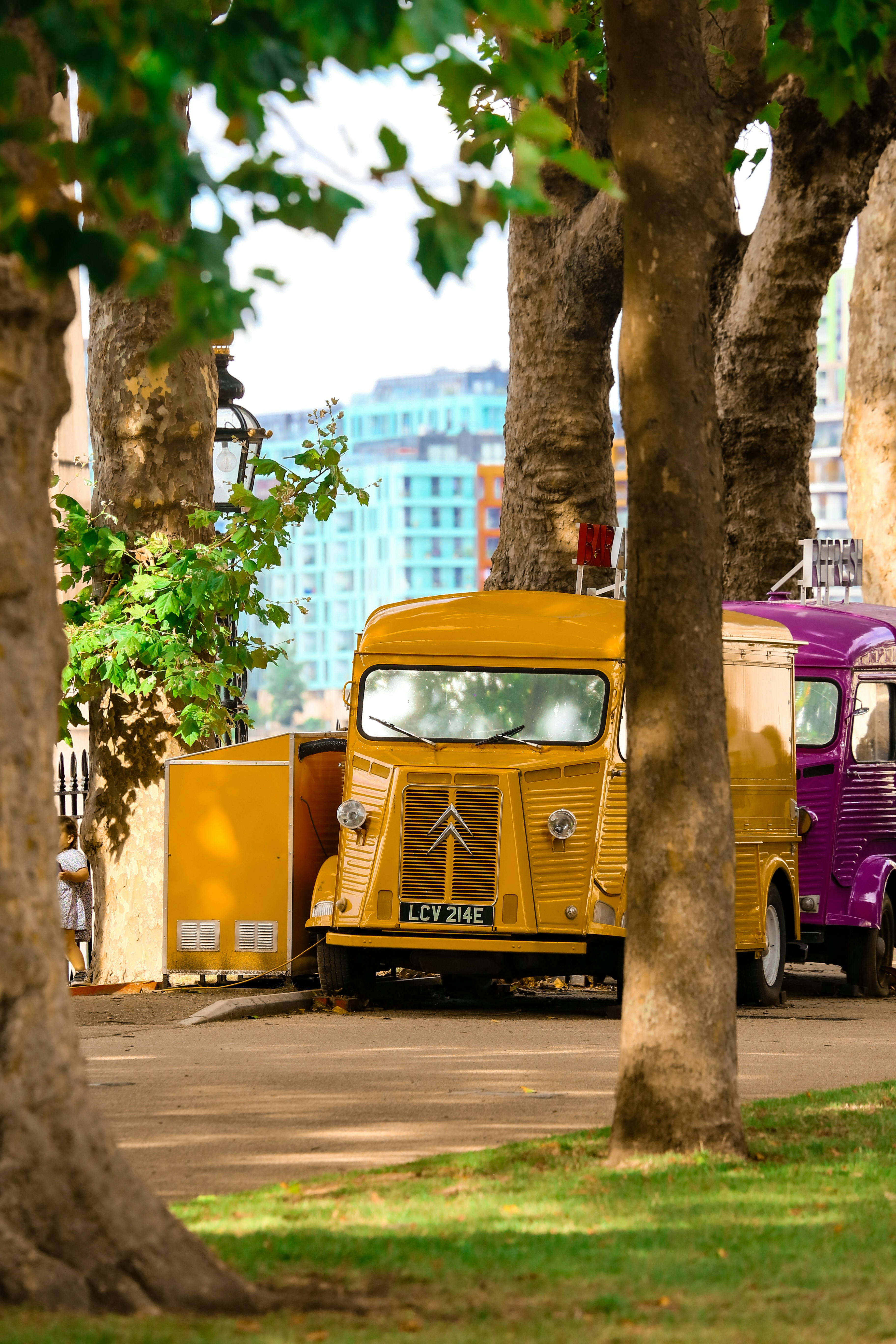 Yellow vintage van parked under trees