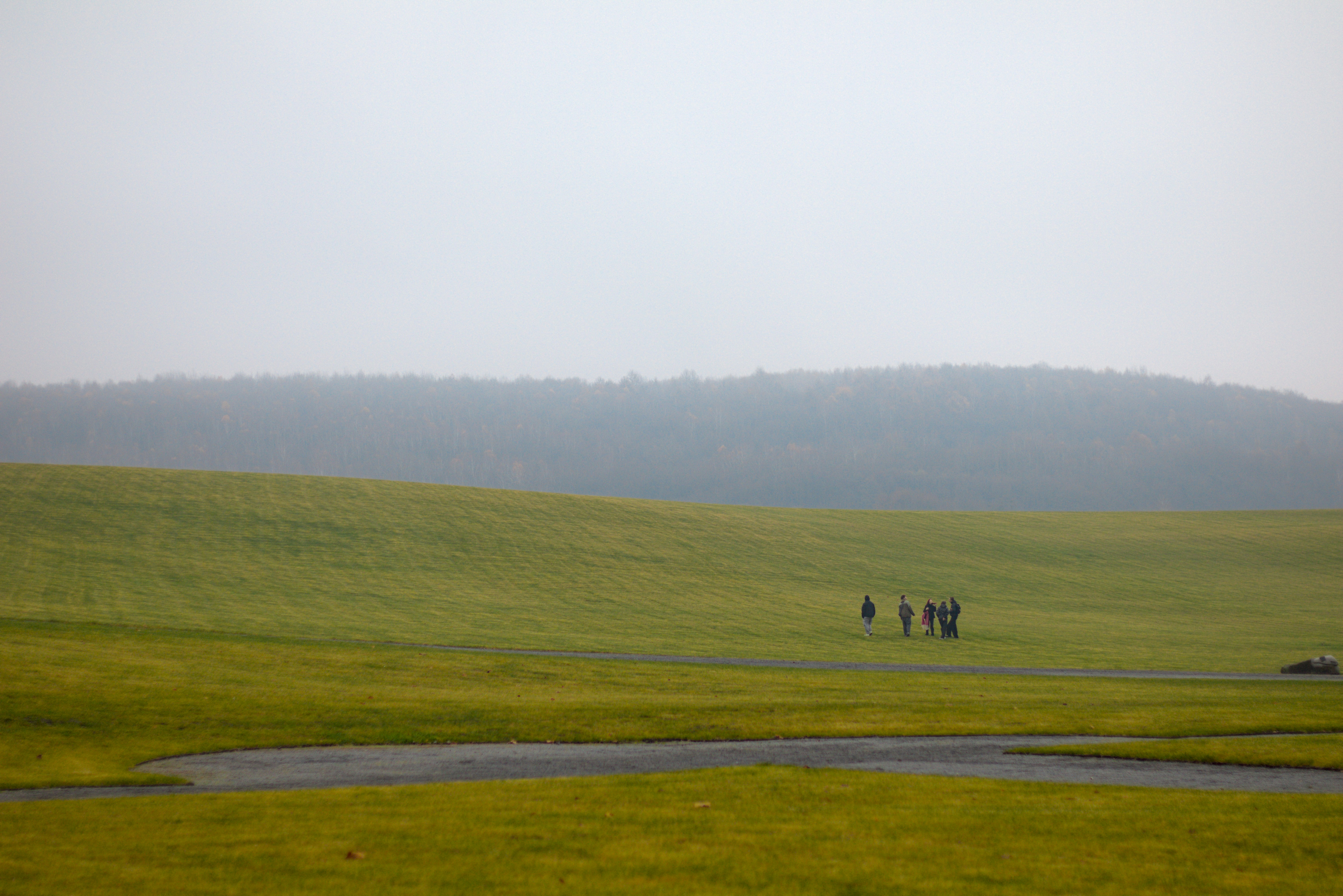 A group of people walking across a grassy field.