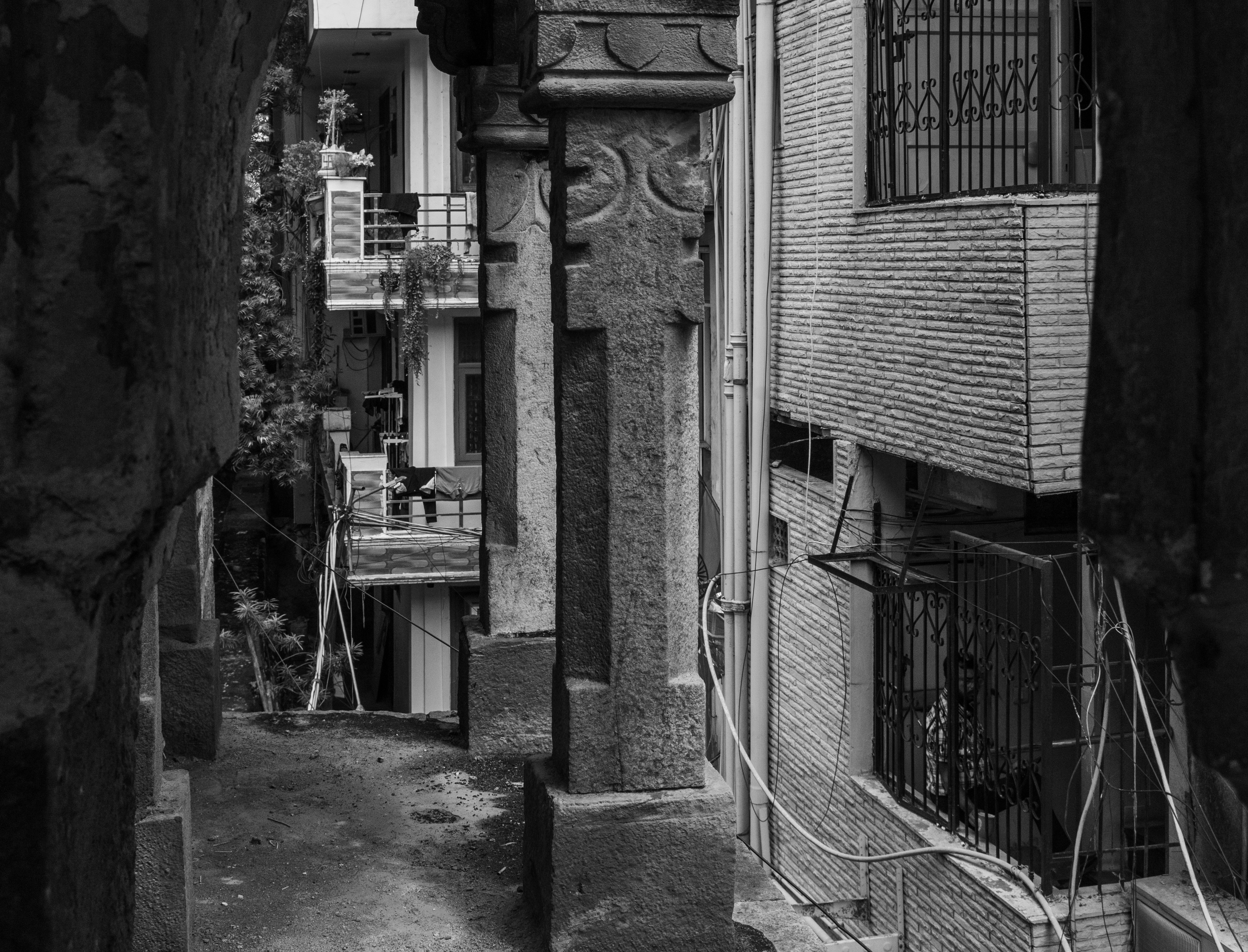 Narrow alleyway between buildings with decorative pillars.