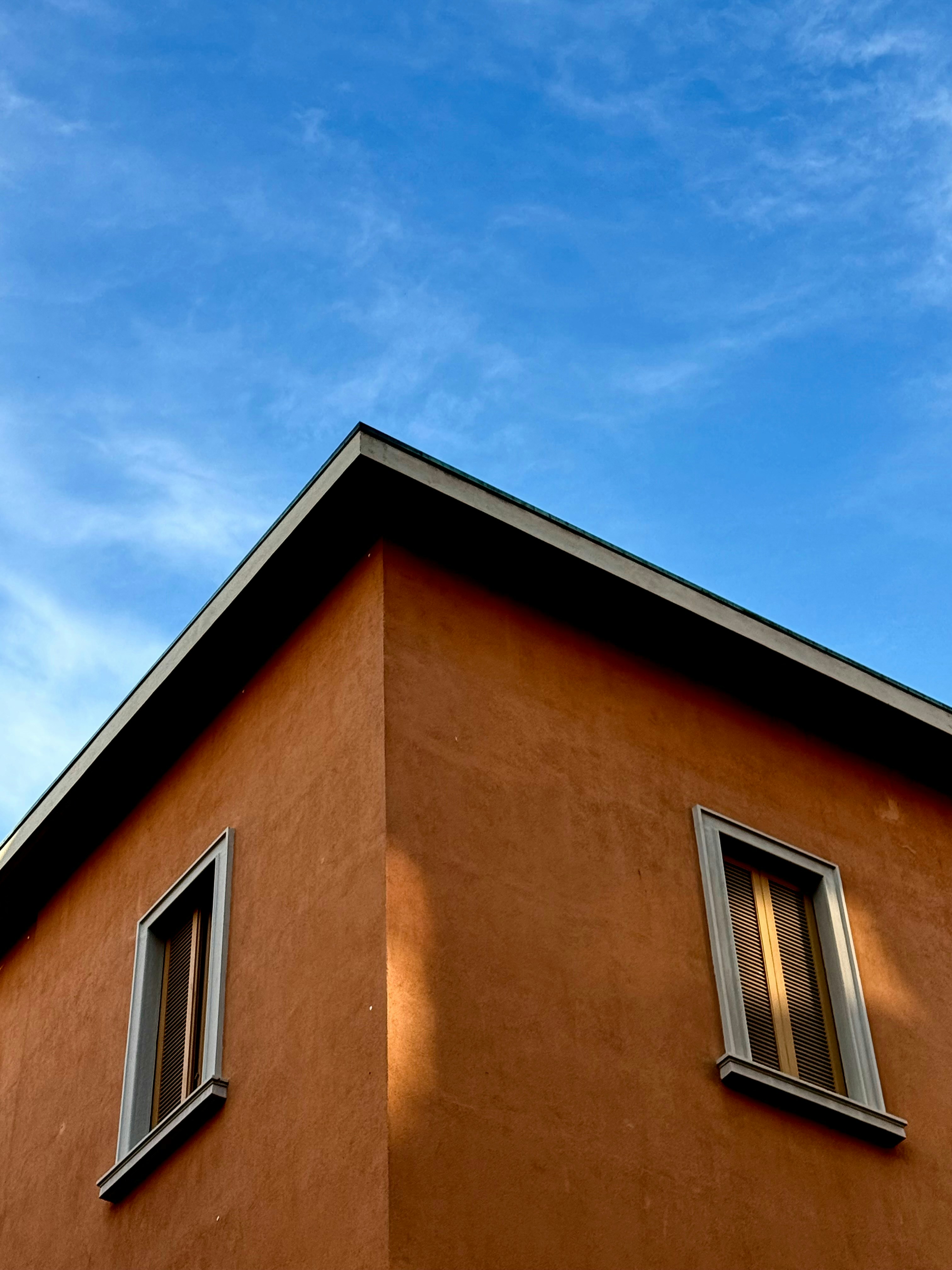 파란 하늘 아래 주황색 건물 모퉁이