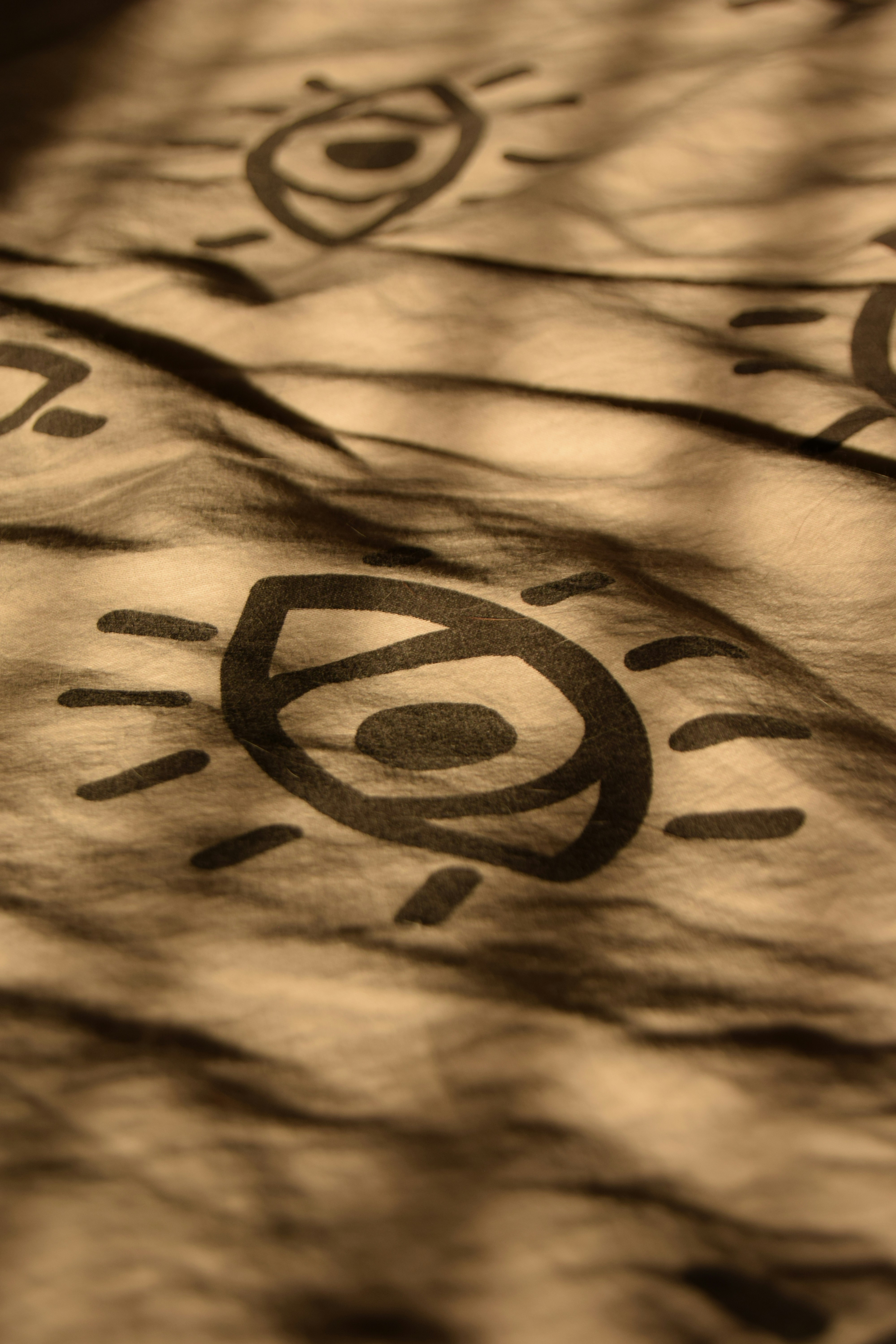 Close-up of fabric with eye pattern and sunburst pattern.