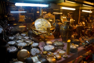 Collection of antique pocket watches and vases displayed artifacts.