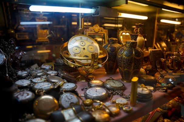 Collection of antique pocket watches and vases displayed artifacts.