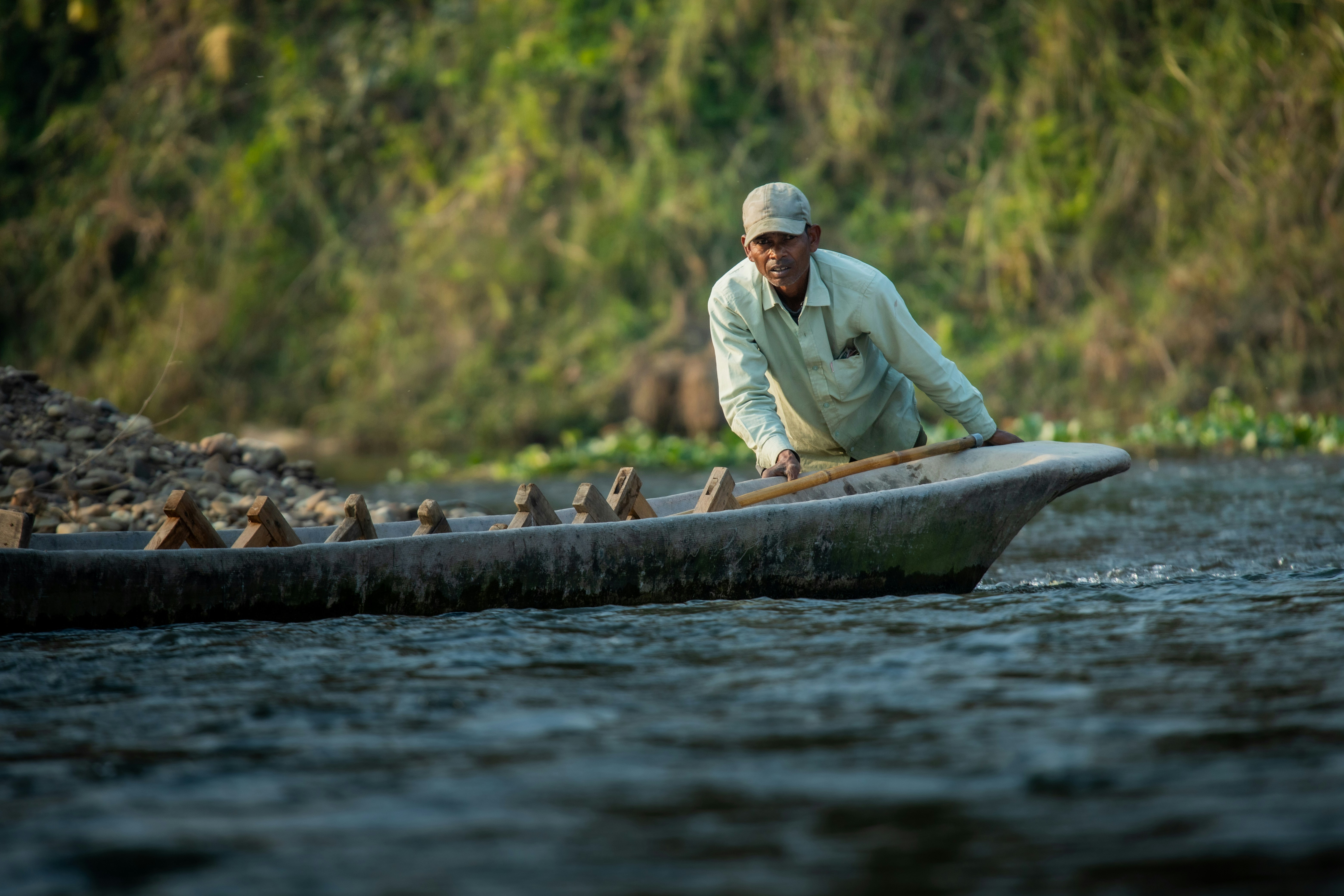Man paddling a traditional canoe through water