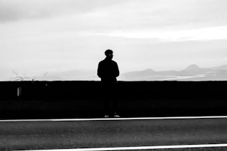 Silhouette of a man standing by a wall