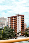 Tall apartment buildings with balconies and palm trees.