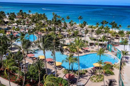 Tropical resort with pools and palm trees by the ocean